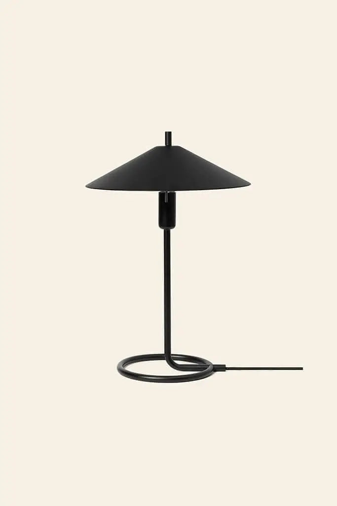 The ferm LIVING Filo Table Lamp features a wide conical shade and minimalist circular base in powder coated iron, set against a beige background—an ideal modern accent for your home.
