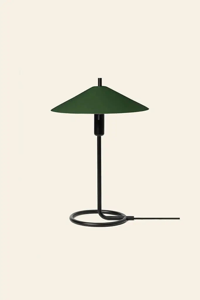 The ferm LIVING Filo Table Lamp pairs a circular black iron base, slim vertical stem, and wide dark green conical shade—an ideal modern home accent, shown here by ferm LIVING against a plain beige background.