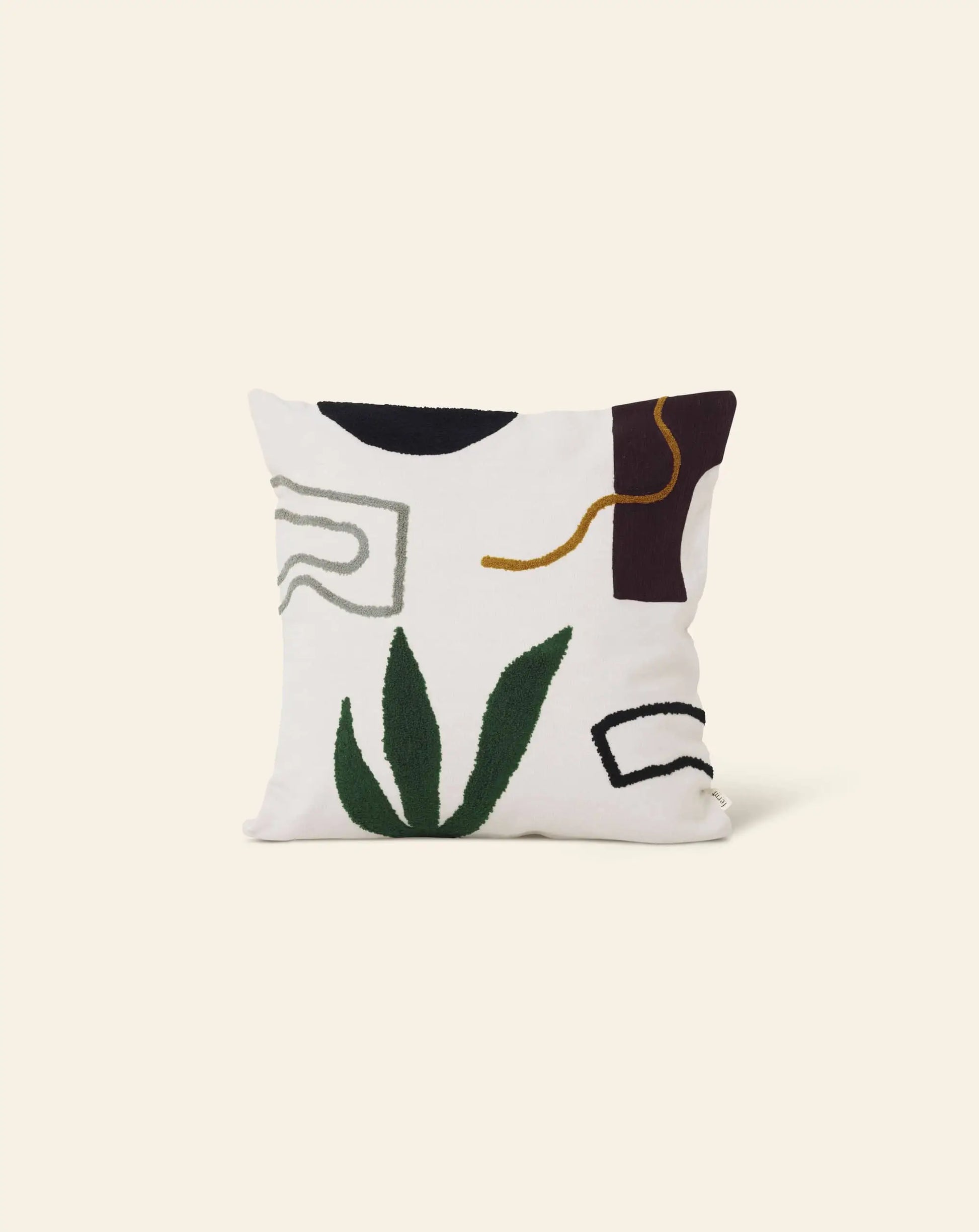 The ferm LIVING Mirage Cushion by ferm LIVING features embroidered green leaf-like shapes and curved lines in black, gray, gold, and burgundy on a white background, creating an abstract nature-inspired design.