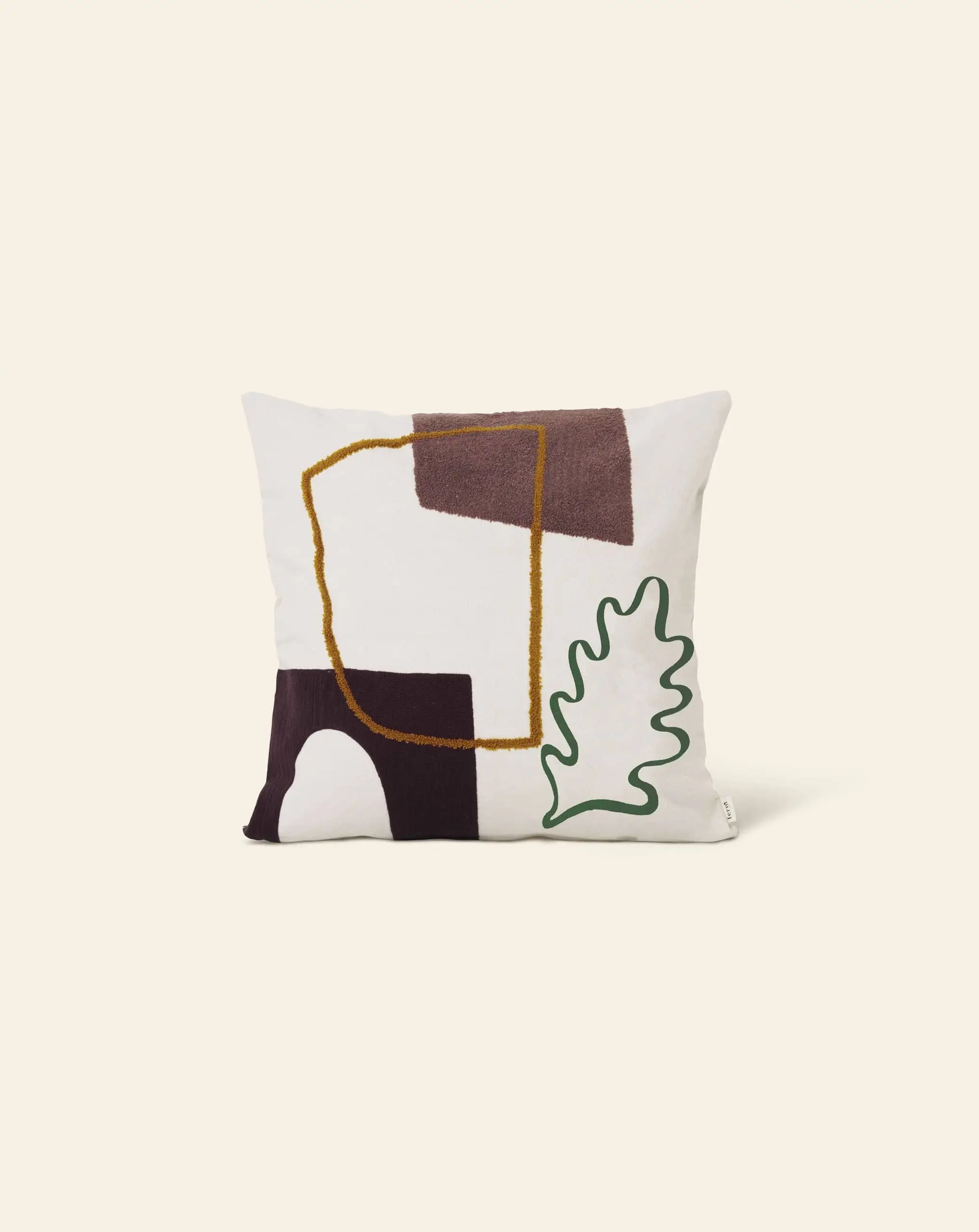 The ferm LIVING Mirage Cushion by ferm LIVING is a square cushion in earthy tones with brown and mustard yellow geometric shapes and an outlined green leaf on a white background, bringing a nature-inspired touch to your space.