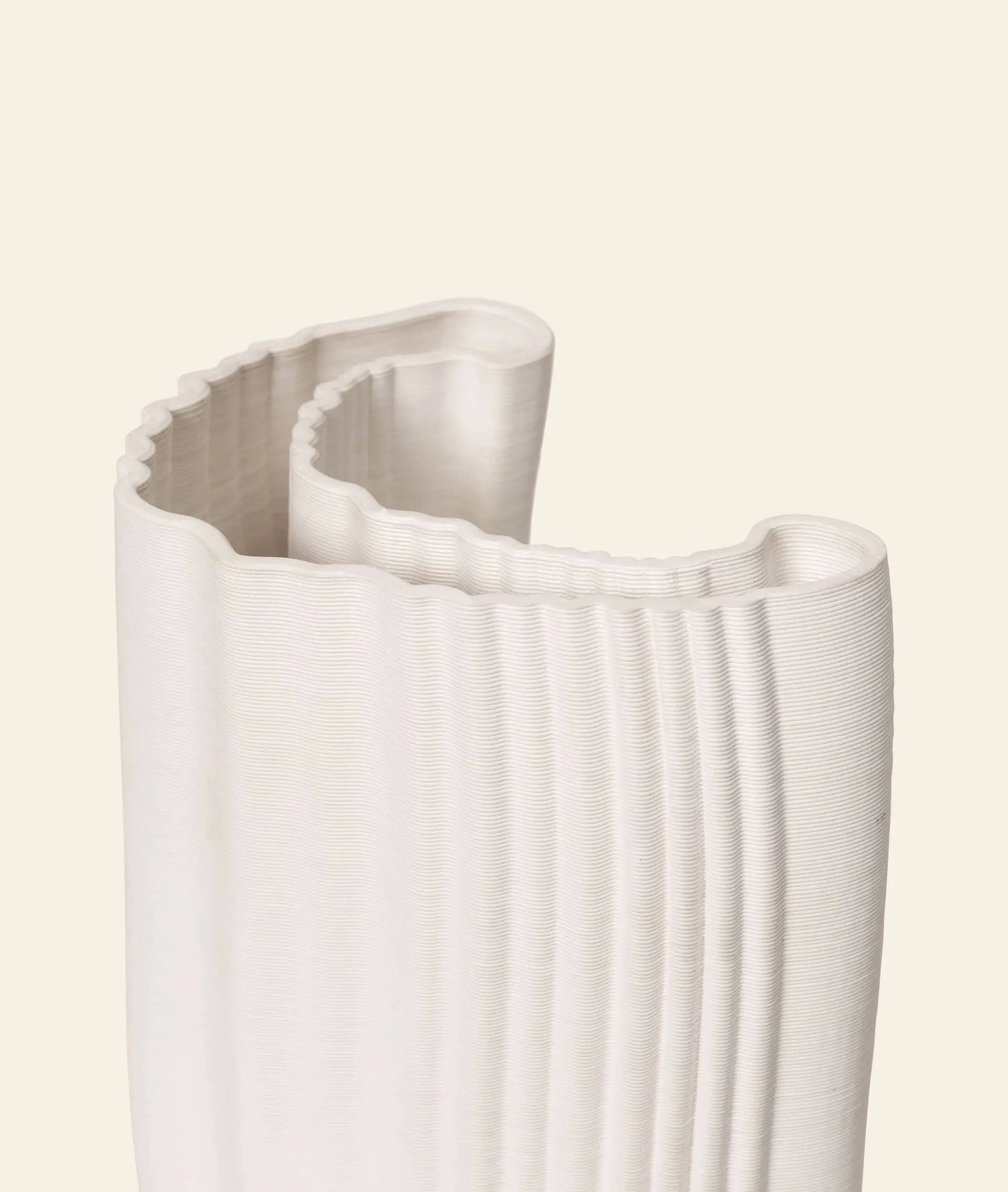 The ferm LIVING Moire Vase by ferm LIVING is a white, vertically ribbed vase with wavy edges. Its textured curves and 3D printed design create a modern, sculptural appeal, shown here against a plain light background.