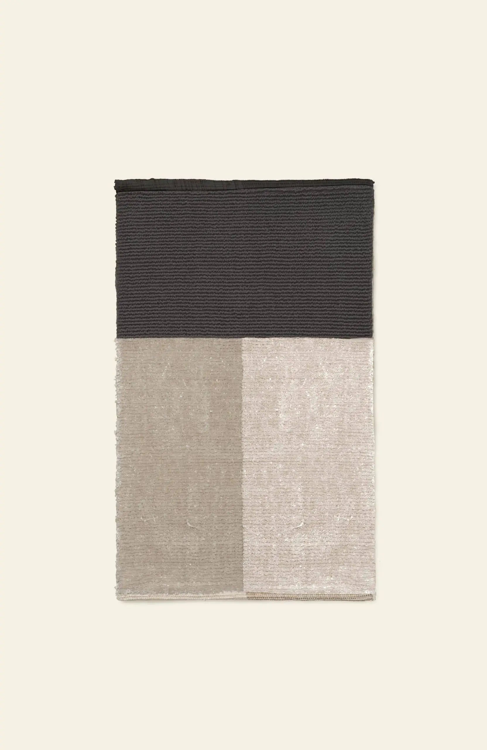 The ferm LIVING Pile Bathroom Mat by ferm LIVING is a rectangular rug with a plush feel, divided into four sections of dark texture and lighter beige and cream tones, crafted from recycled polyester on a light background.