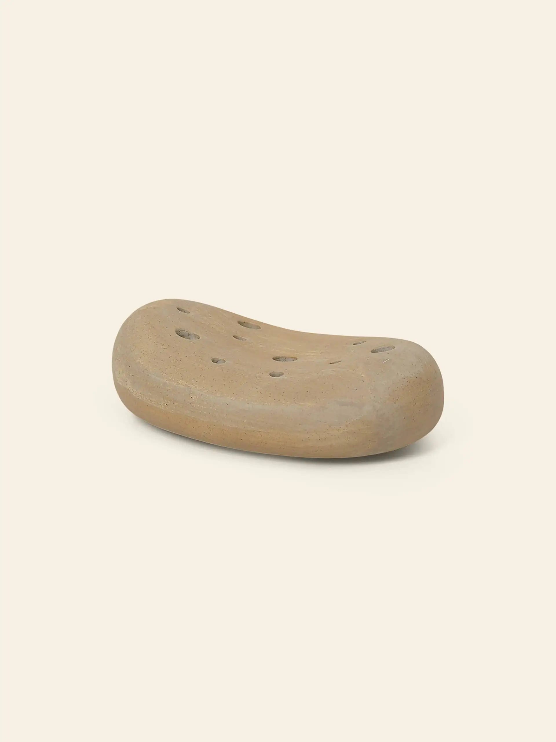 The ferm LIVING Vanitas Flower Stone by ferm LIVING is a beige, pebble-shaped glazed porcelain soap dish with drainage holes—an elegant accessory for modern spaces.