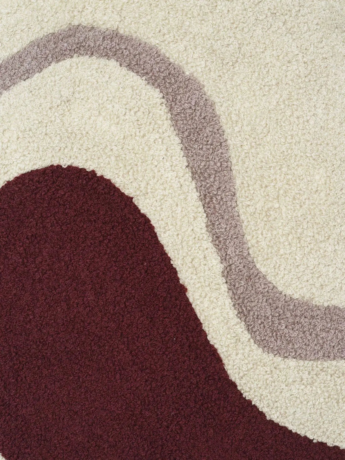 The ferm LIVING Vista Cushion by ferm LIVING showcases a cream background with a large maroon curved shape and a wavy taupe stripe, perfect for bringing luxurious modern style to your home.
