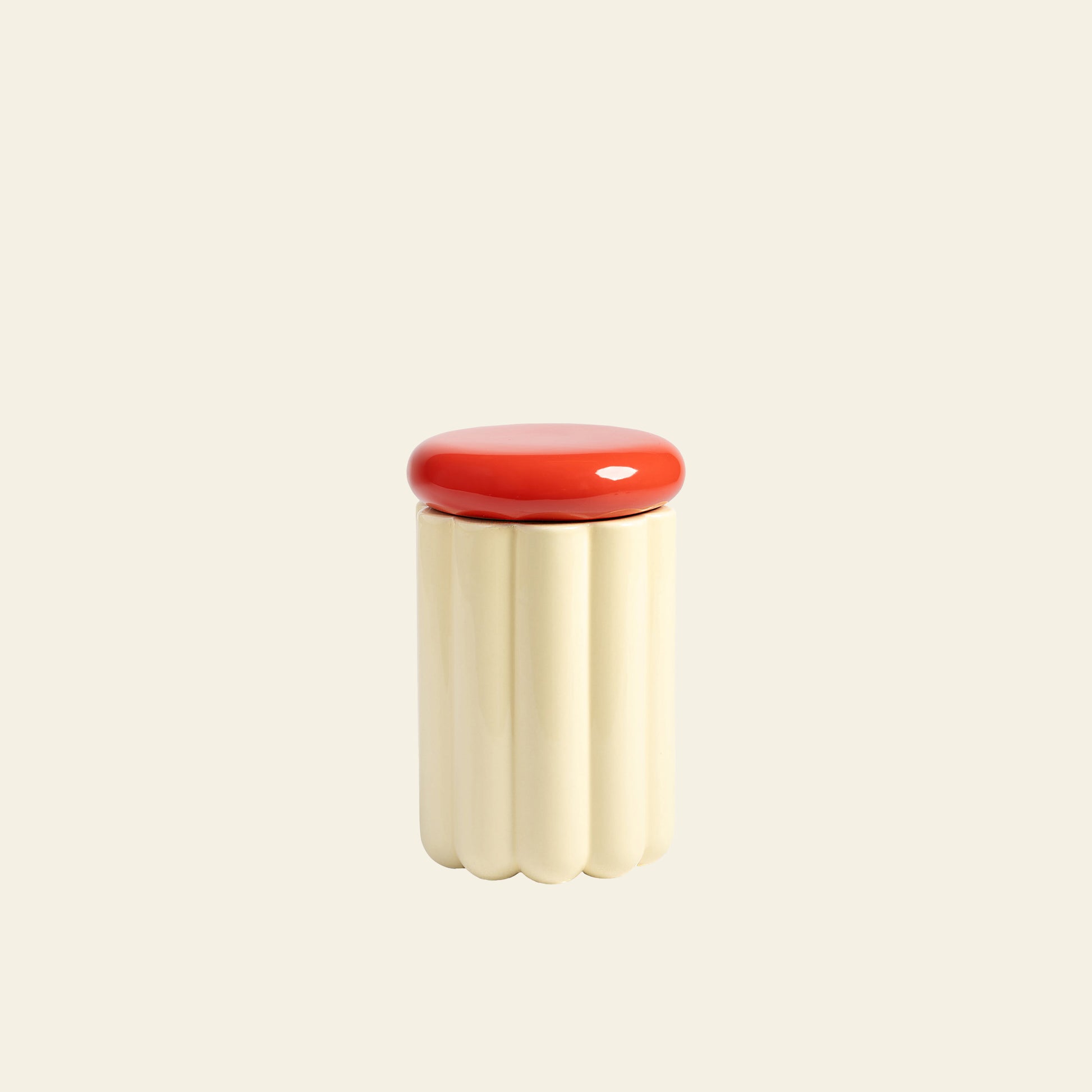 The &klevering Charlo Jar - Off-White features a wavy, cream body and a smooth red lid for airtight freshness, shown on a plain beige background.