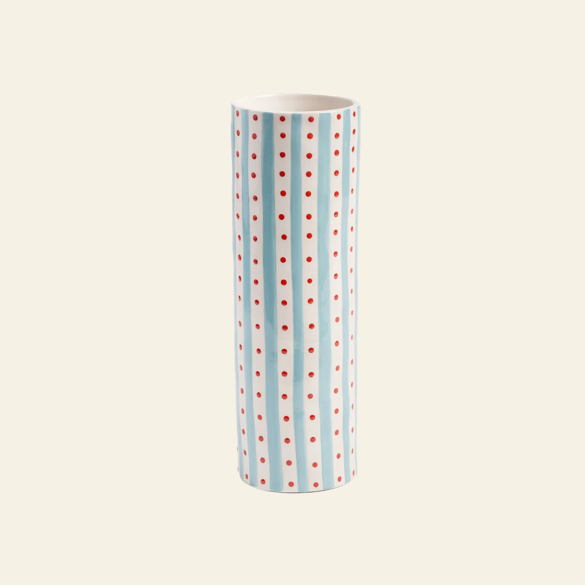 The &klevering Clash Dot Vase by &klevering features hand-painted light blue stripes and red polka dots on a white base, creating a tall, modern storage piece that stands out against any off-white backdrop.