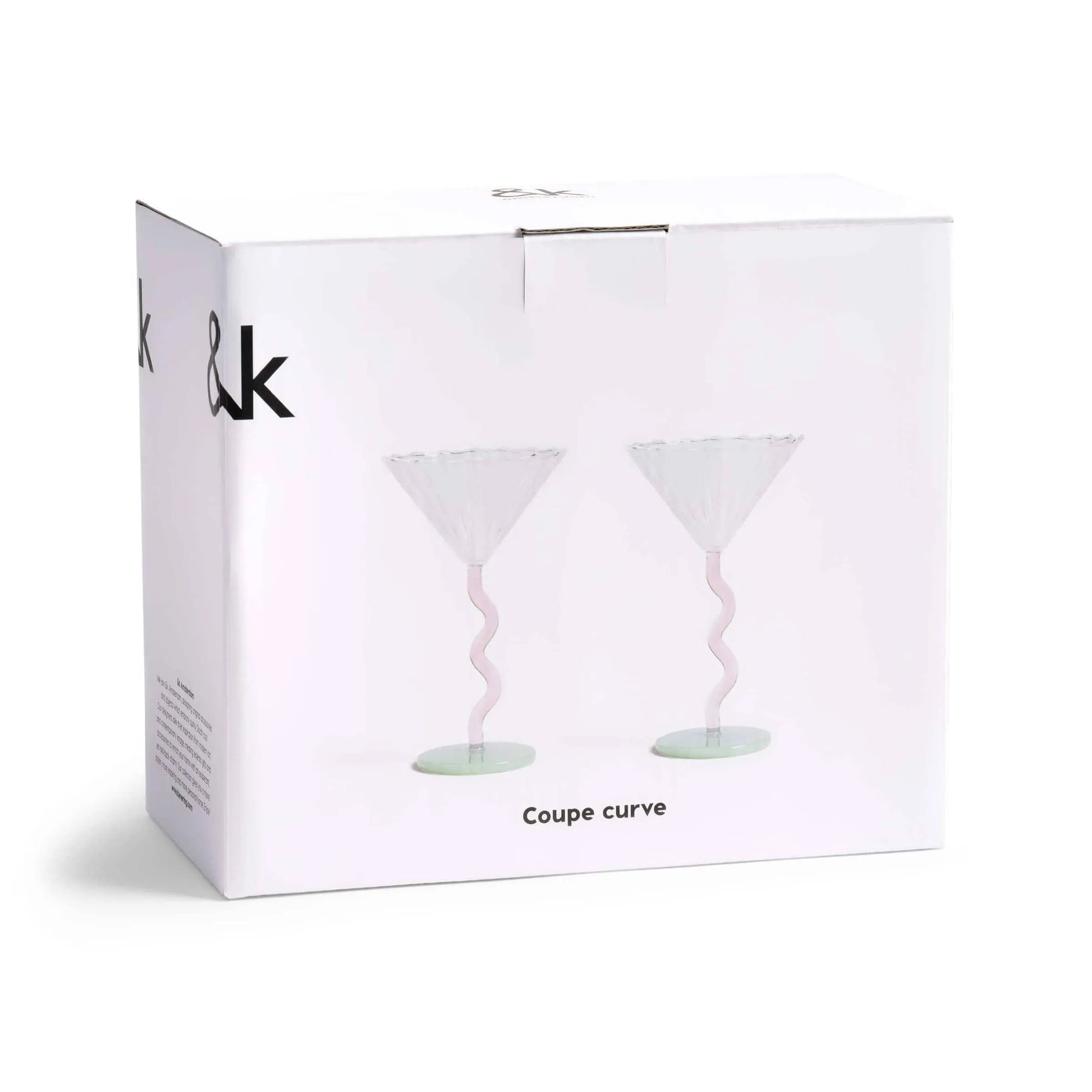 A white box displays two &klevering Curved Coupe Glasses—elegant, wavy pink stems and wide bowls—ideal for celebrations. “Coupe curve” is printed below the glass images. Set of 2 by &klevering.