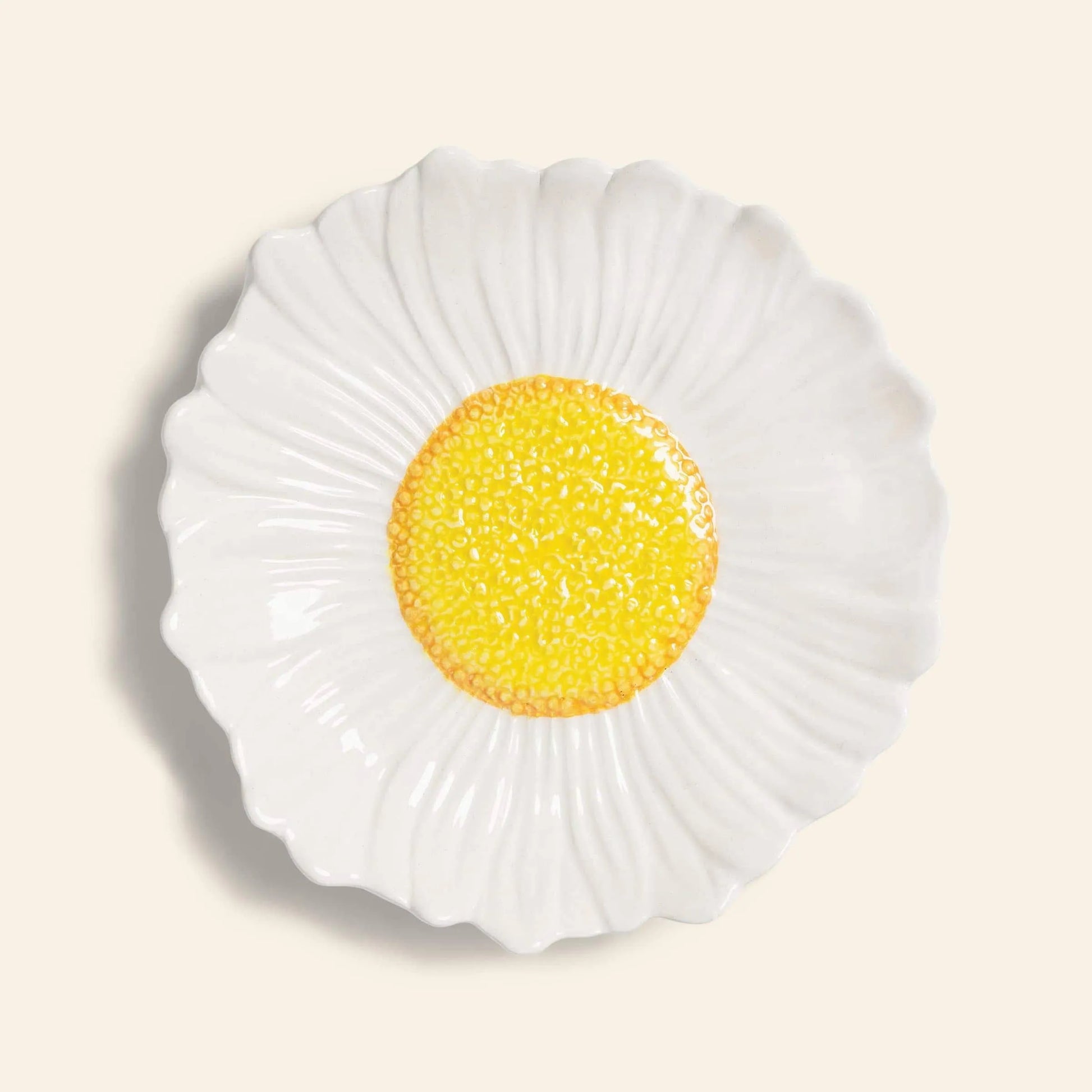 The &klevering Daisy Bowl by &klevering features textured white ceramic petals and a bright yellow center, making it perfect for garden dinners or summer picnics.