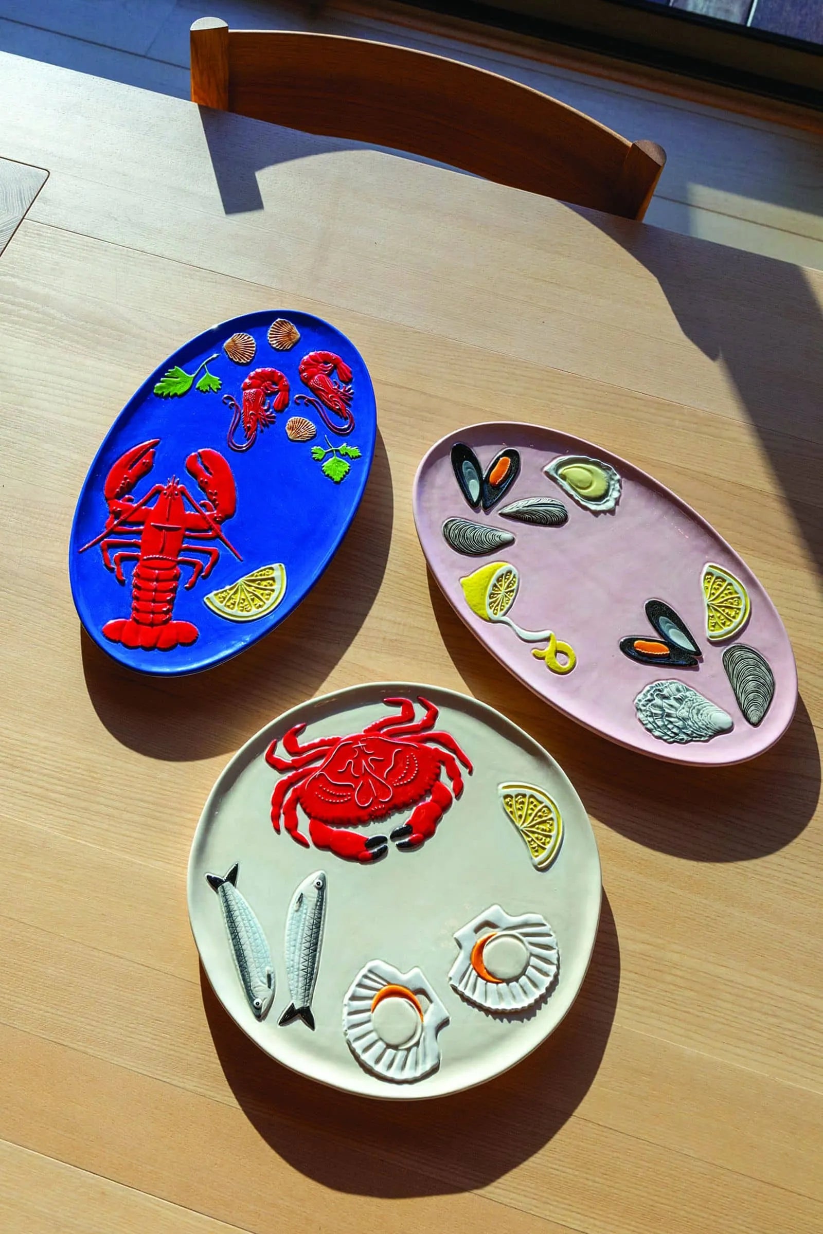 The &klevering De La Mer Crab Platter by &klevering features a colorful crab, fish, and shells on white ceramic—part of a decorative collection inspired by vibrant sea life.