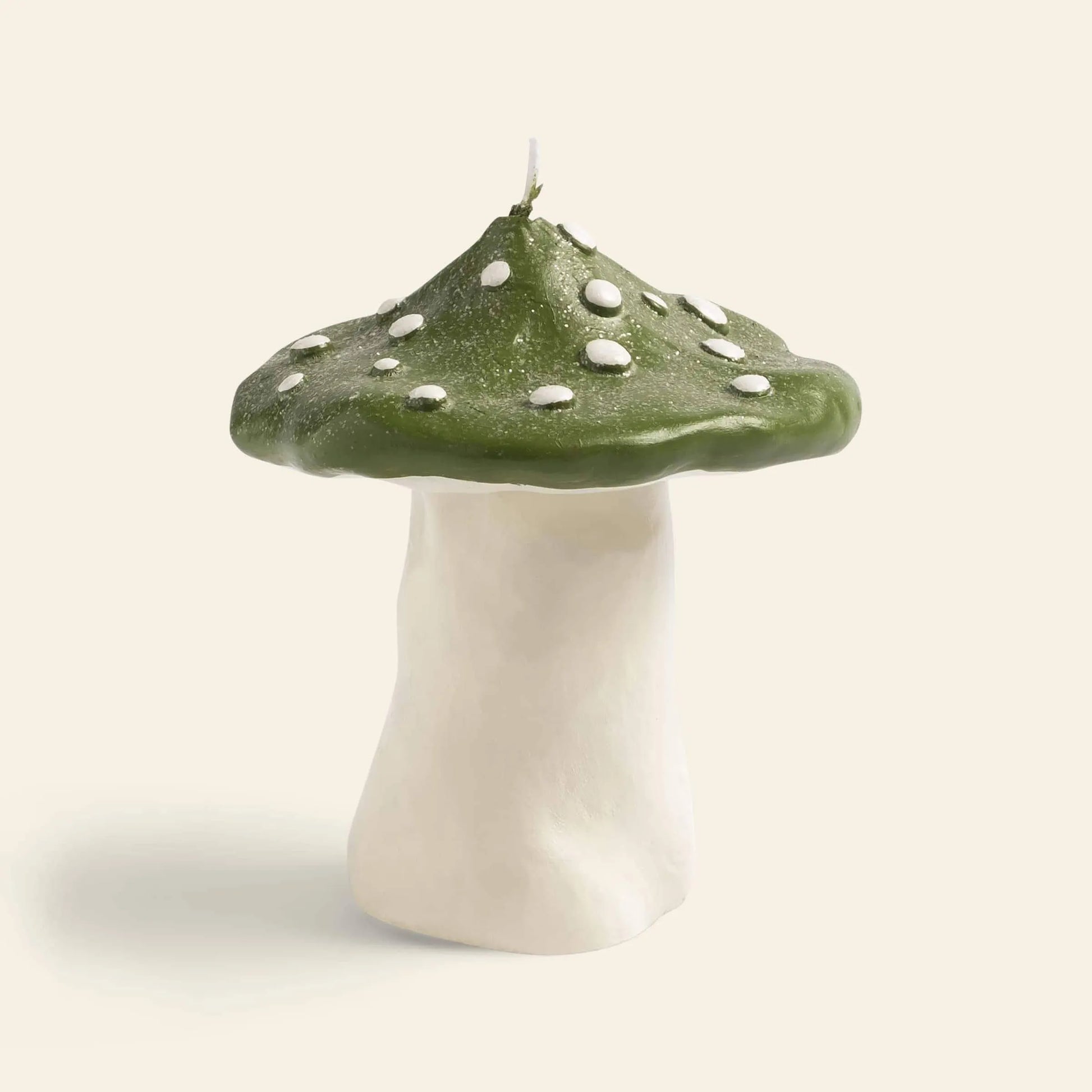 The &klevering Dots Mushroom Candle by &klevering features a white stem and a green cap with white spots, creating an enchanting ambiance against a plain, light background.