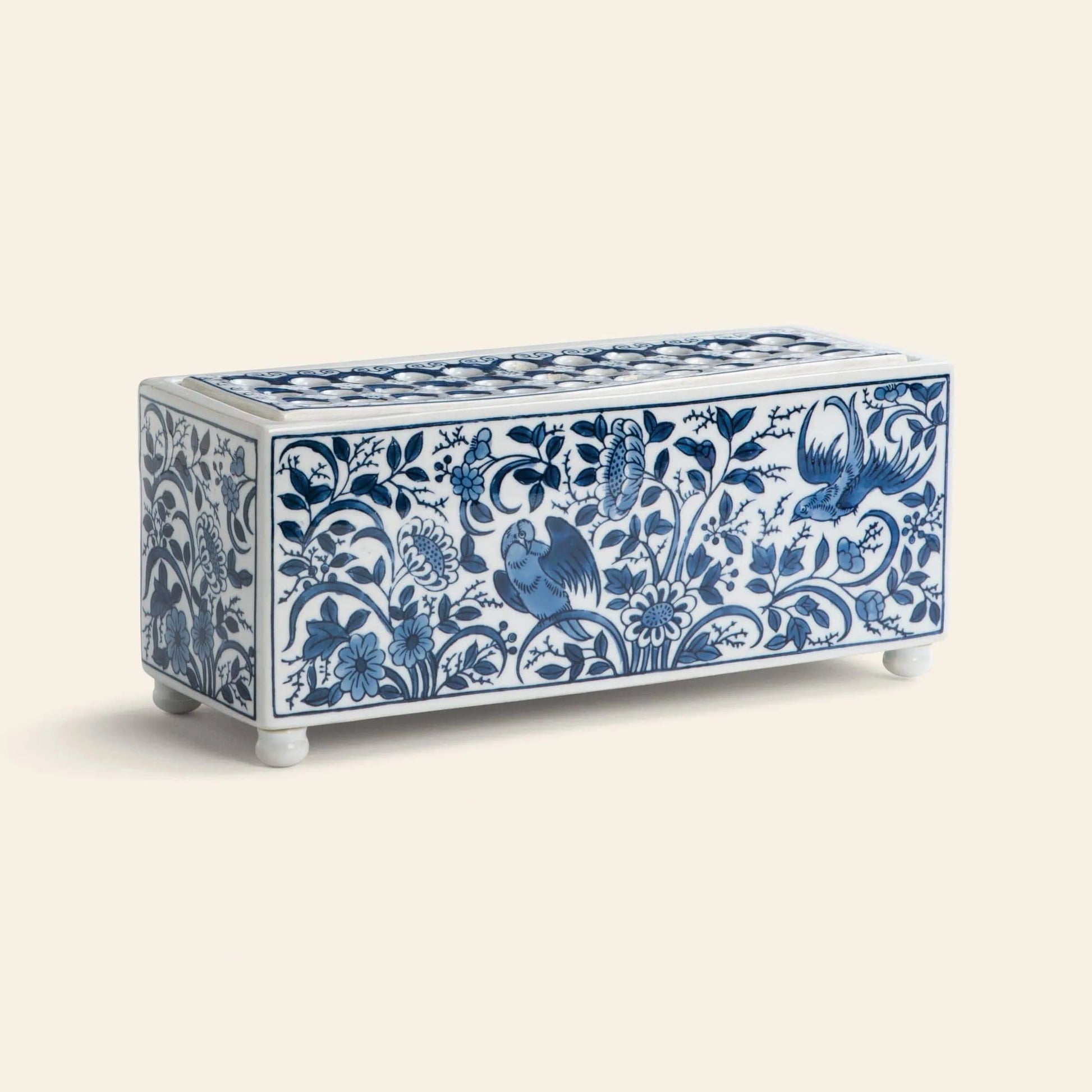 The &klevering Flowerbrick Vase is a rectangular ceramic box with a lid, featuring blue and white floral and bird Faience-style patterns, four small round feet, and is displayed against a plain light background.