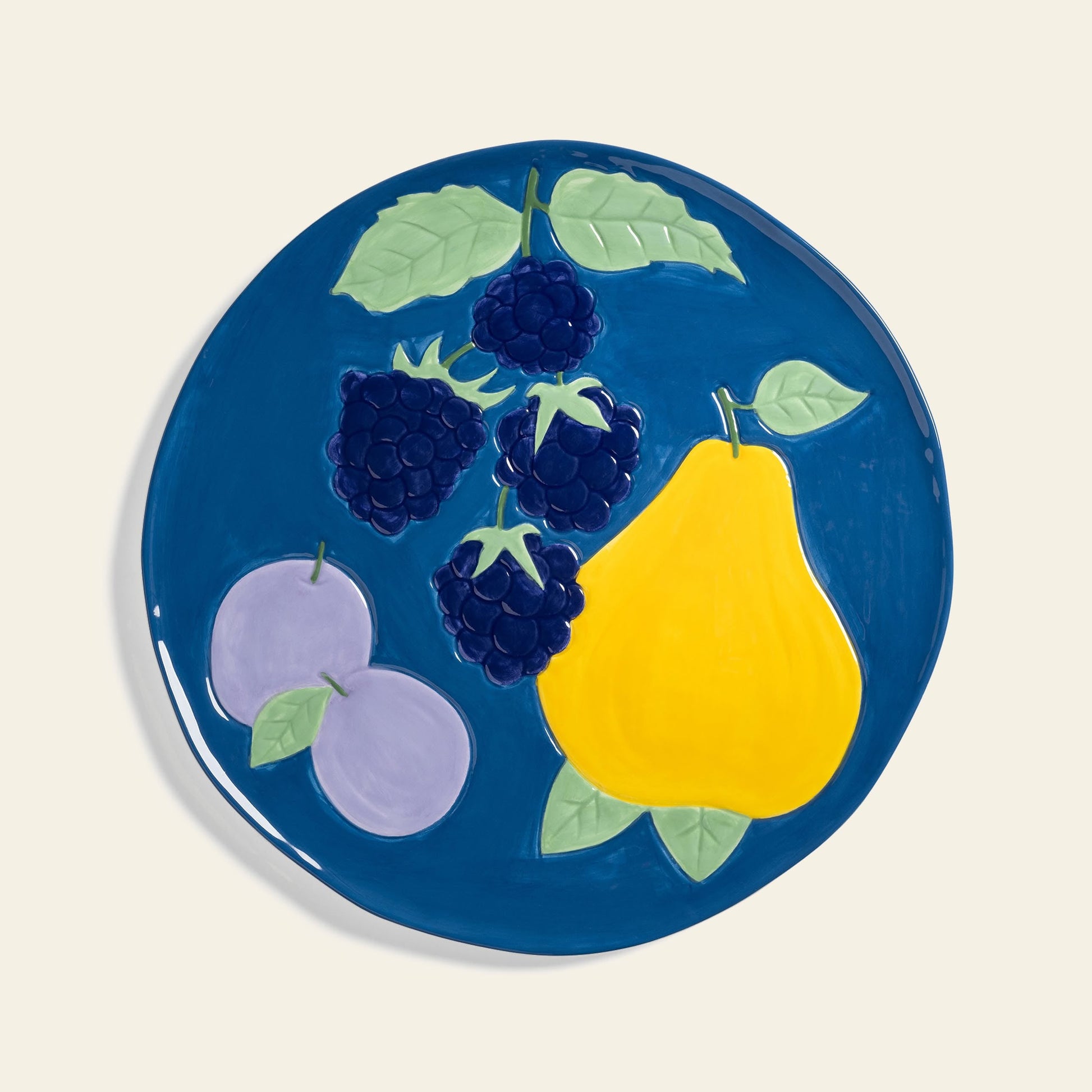 The &klevering Fruitful Blackberry Platter by &klevering is a ceramic plate with a blue background and a vintage fruit collage—blackberries, yellow pear, and purple plums—ideal for enhancing any table setting.