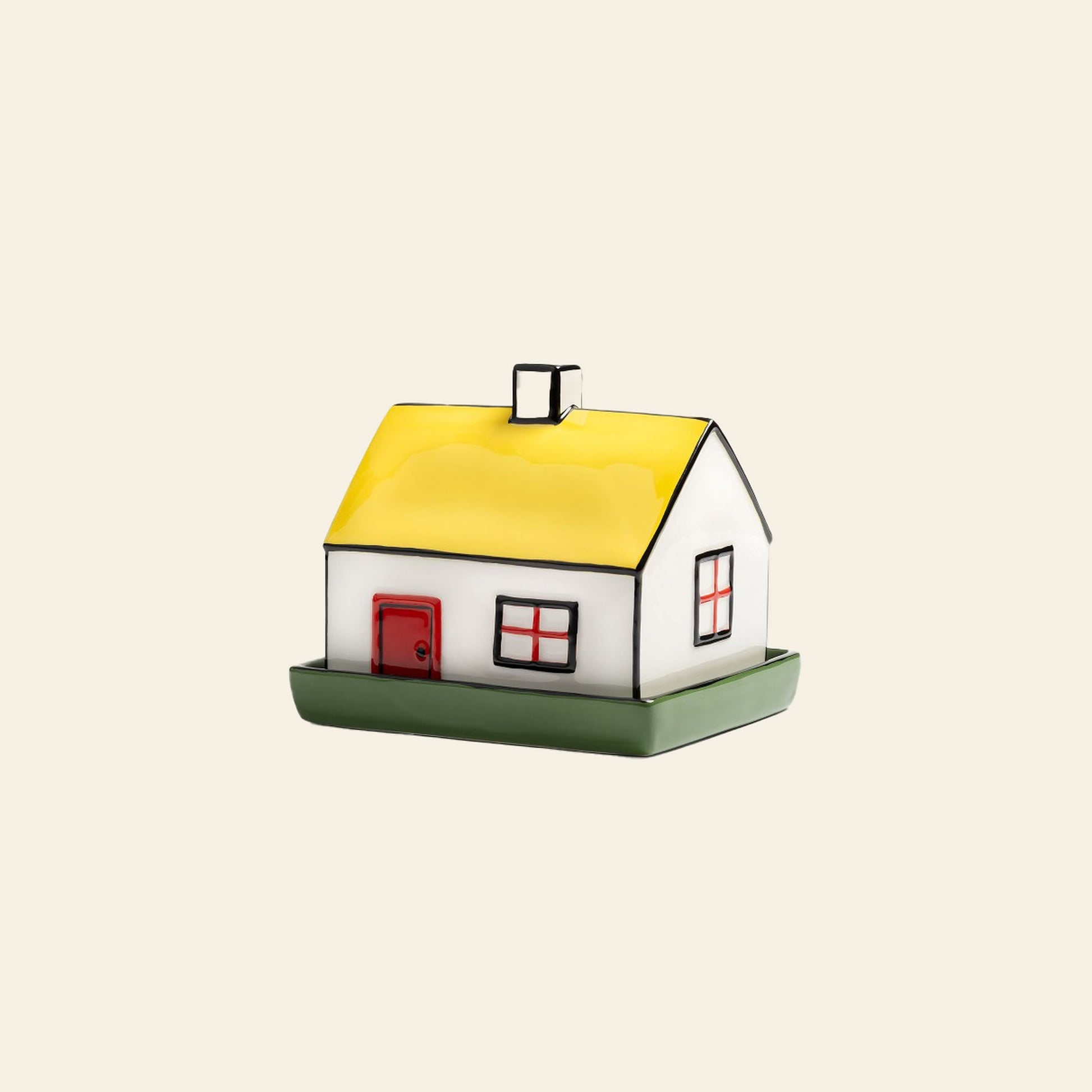 The &klevering Haines Butter Dish by &klevering is a small ceramic house with a yellow roof, red door, and windows on a green base—its playful design brings English breakfast table charm against a light backdrop.