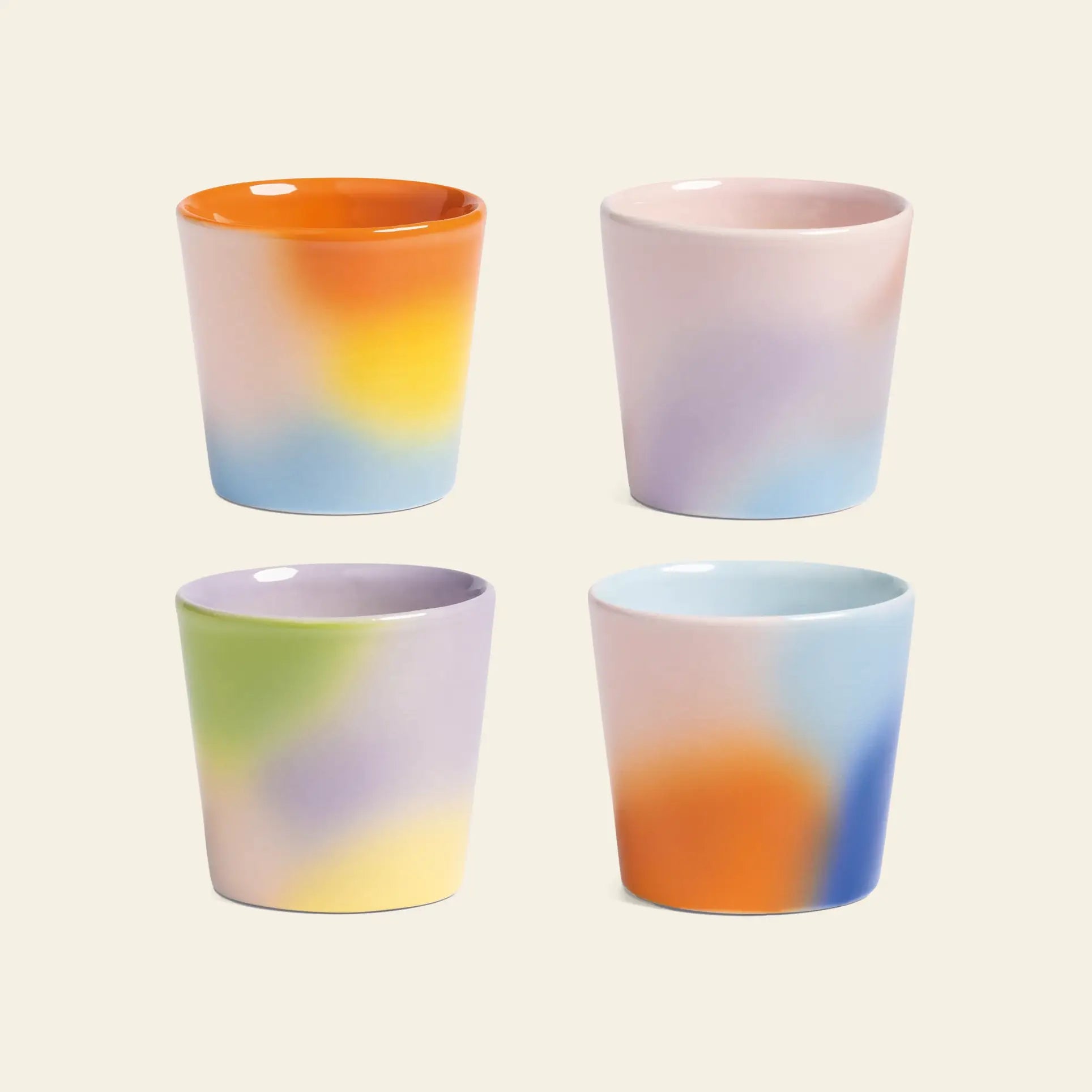 Four &klevering Hue Mug Small mugs, sold as a set of 4, are arranged in a grid on a plain light background, each showcasing unique pastel gradients in orange, pink, blue, yellow, green, and purple.