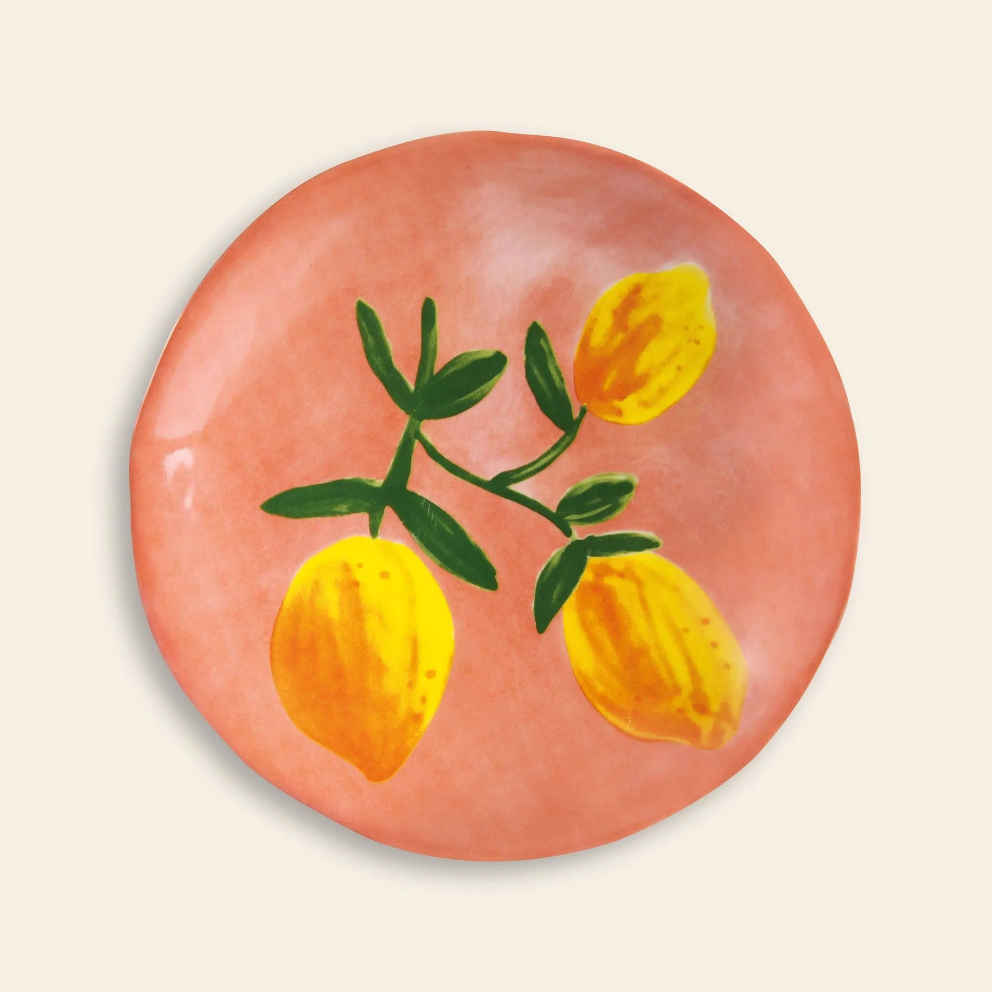 The &klevering Lemon Plate Set of 4 features round ceramic plates with a pinkish-orange background and a painted design of three yellow lemons with green leavesโideal for bringing color to your summer table.