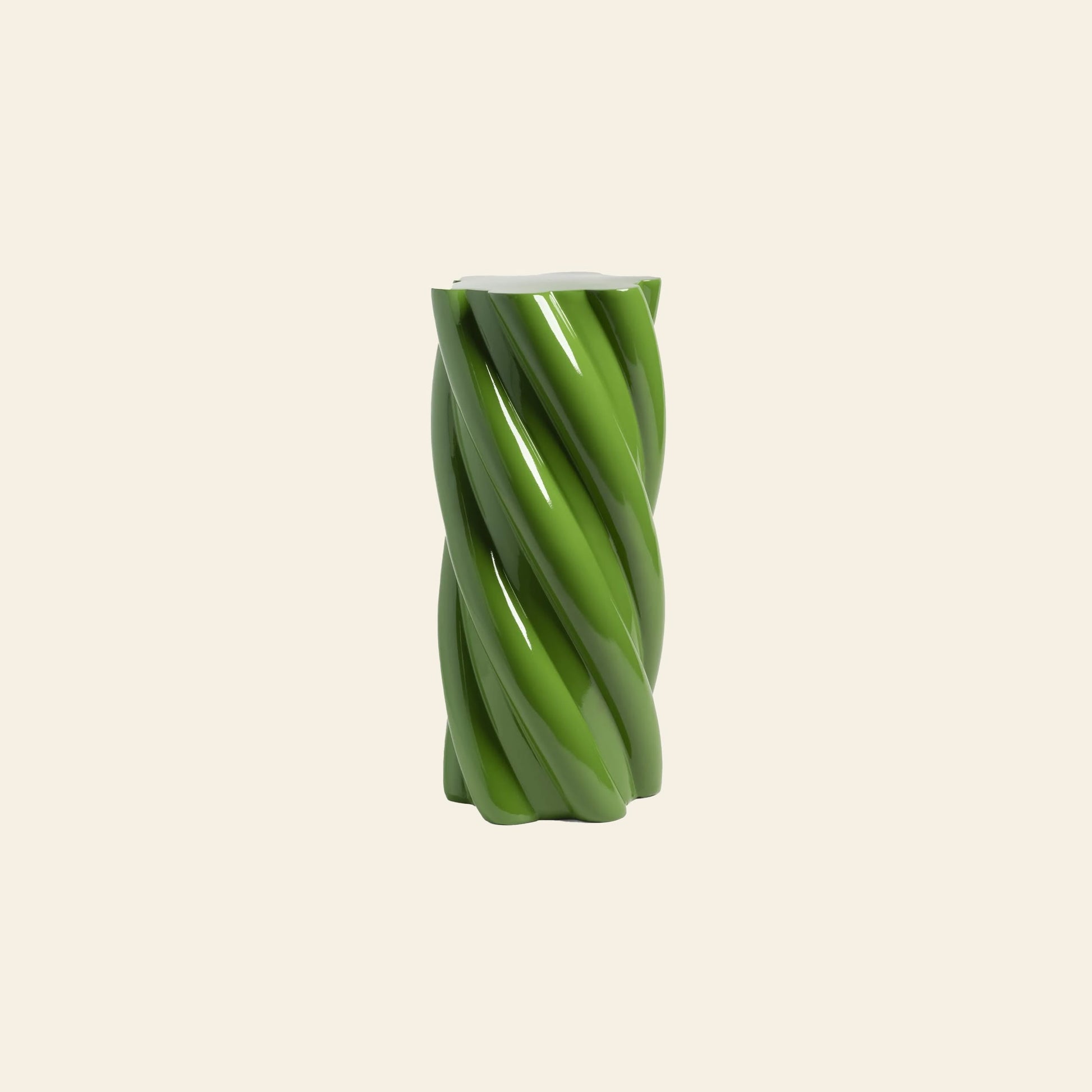 A glossy, green &klevering Marshmallow Pillar with a whimsical twisted cylindrical design stands centered on a plain light beige background.