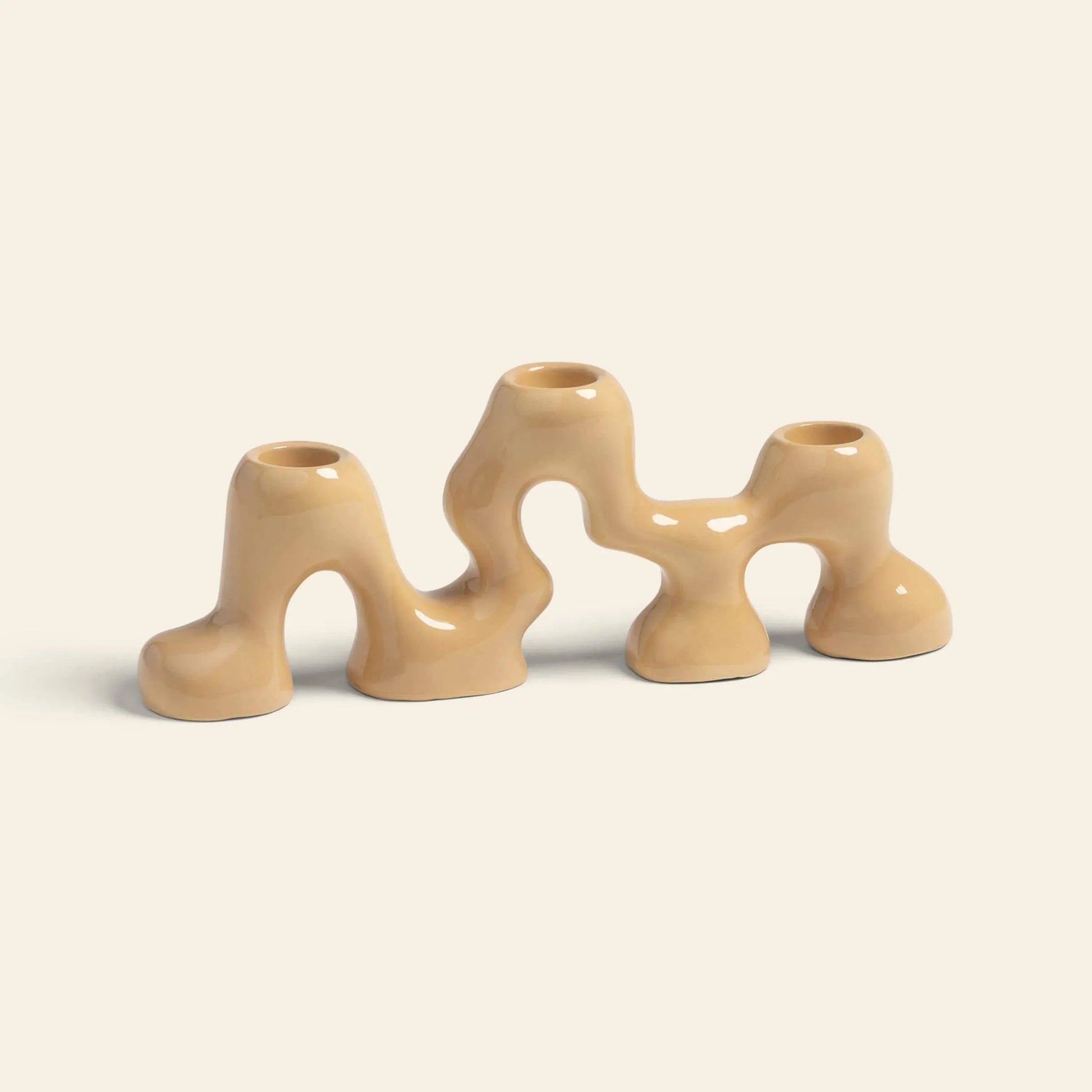 The &klevering Onda Small Candle Holder is a glossy, wavy beige ceramic piece with three openings and organic, interconnected curves, crafted by &klevering and shown against a plain light background.