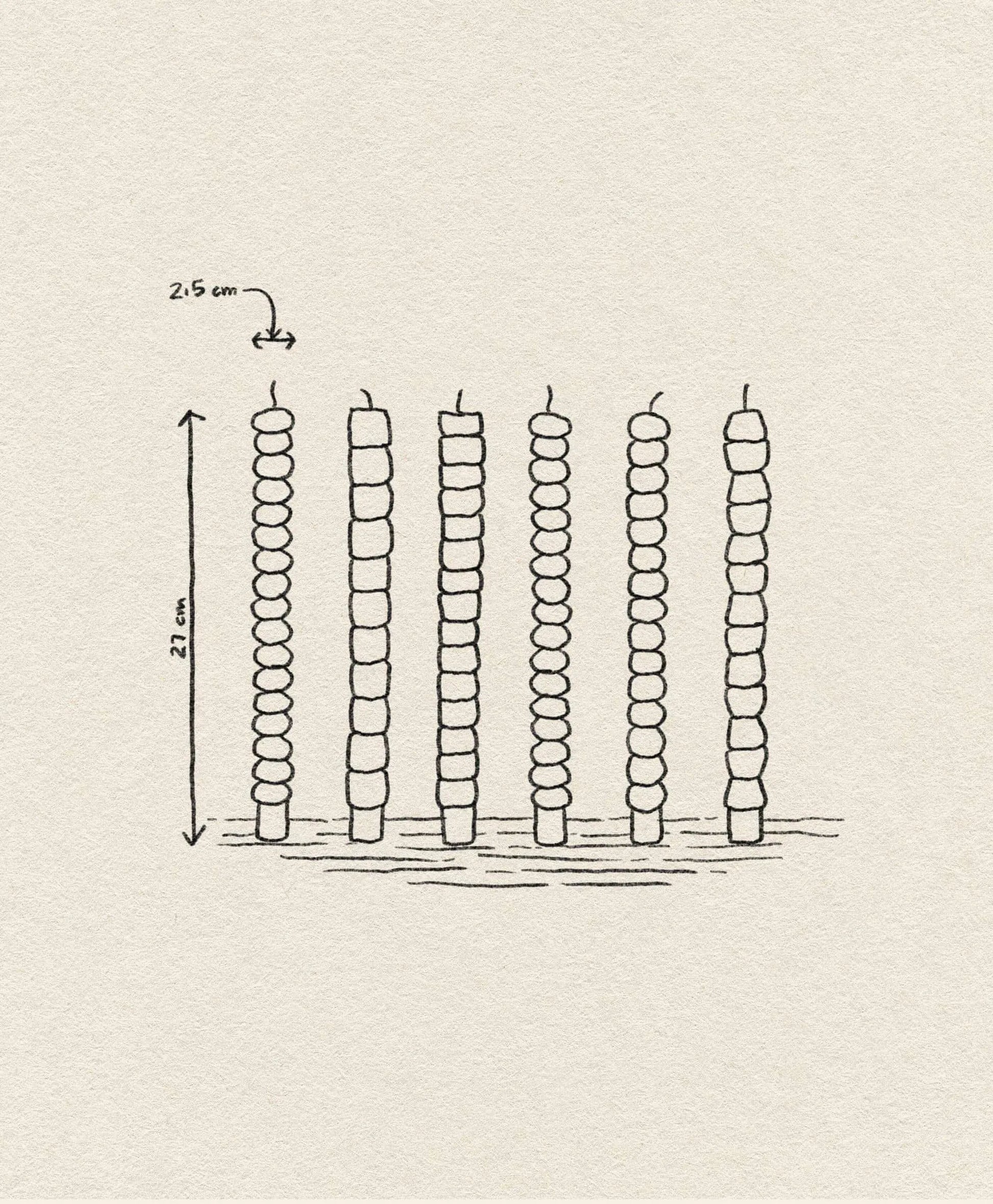 A hand-drawn illustration showcases the &klevering Pebble Candle Set of 6, each 21 cm tall and spaced 2.5 cm apart, with unique color accents—evoking handcrafted charm on a textured surface.