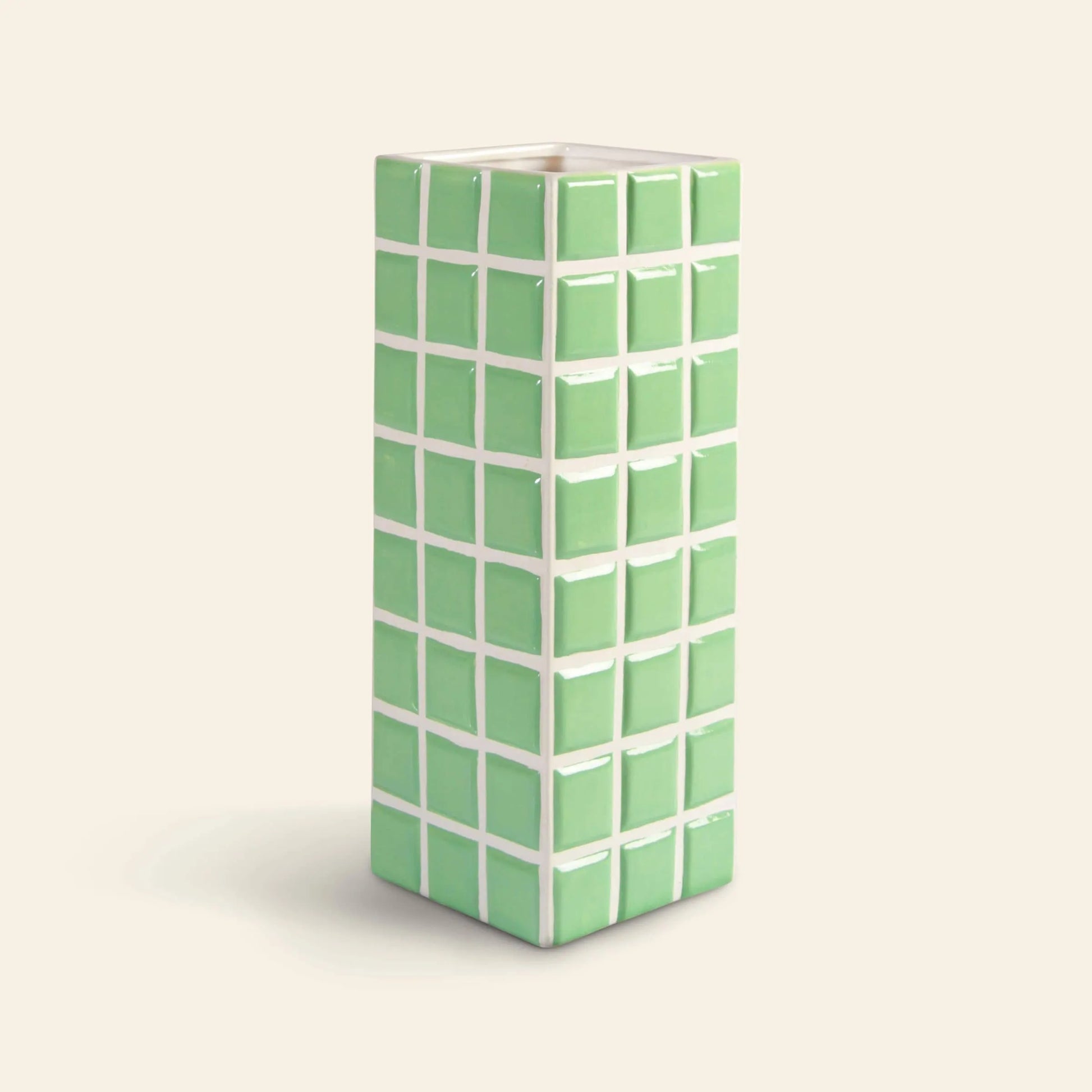 The &klevering Tiled Vase Mint by &klevering is a tall, rectangular ceramic vase featuring raised green square tiles outlined in white on a light background.