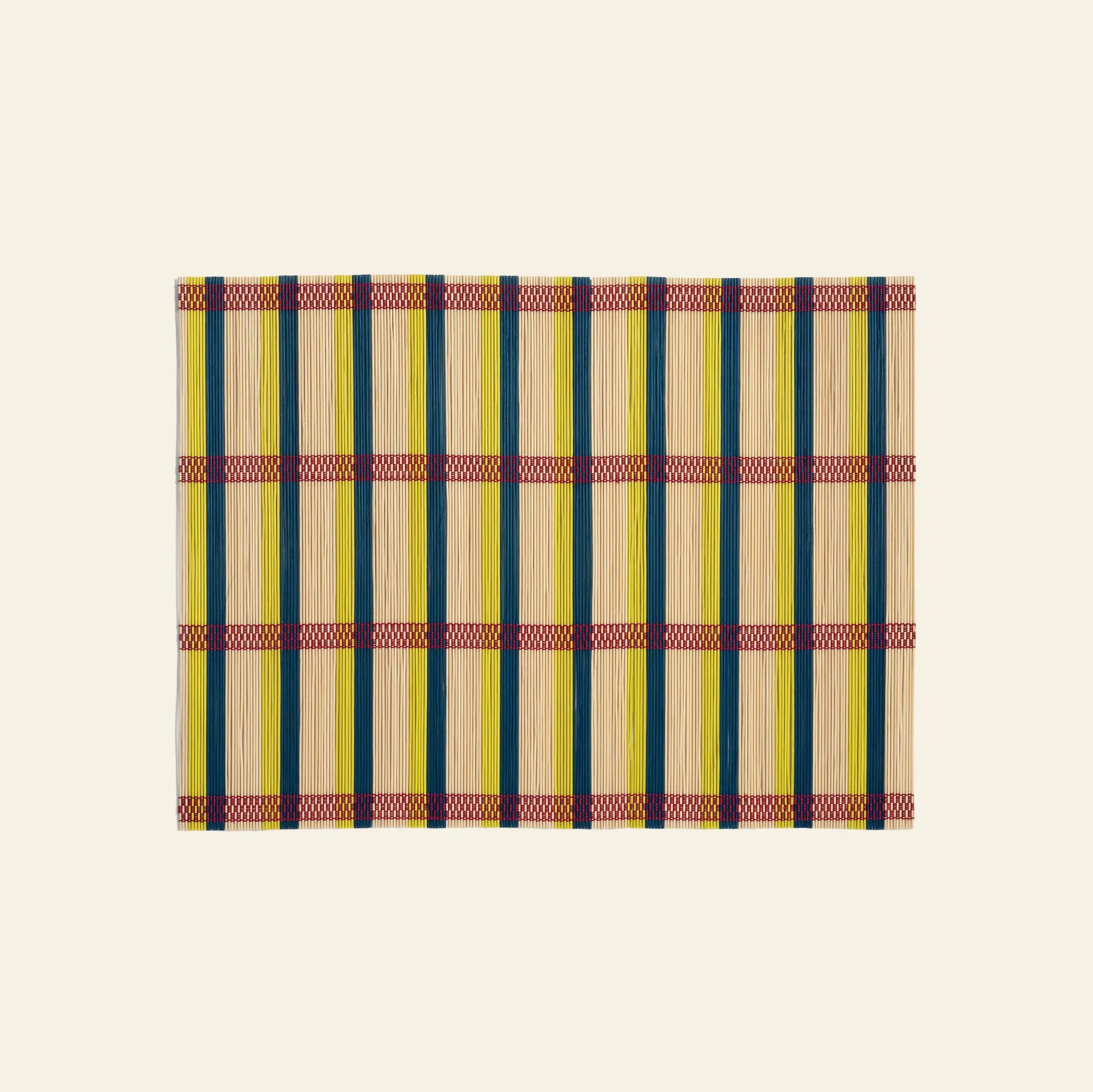 The &klevering Umami Placemat, Set of 4, features a rectangular bamboo design with green, yellow, and natural stripes plus red and purple bands—ideal for a vibrant dining setup. Displayed on a plain beige background.