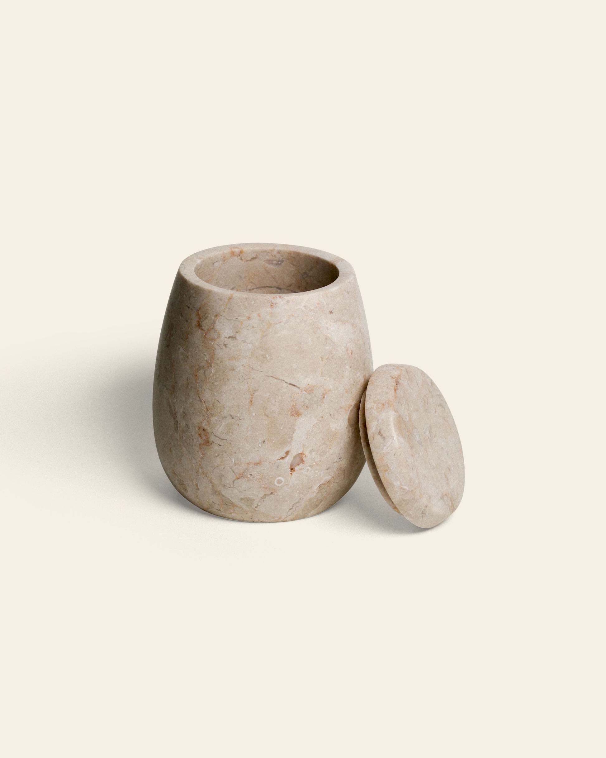 The stillgoods Ecru Jar, a round, light beige marble container with a matching lid, sits against an off-white background—perfect for storing condiments or as a versatile organizer.