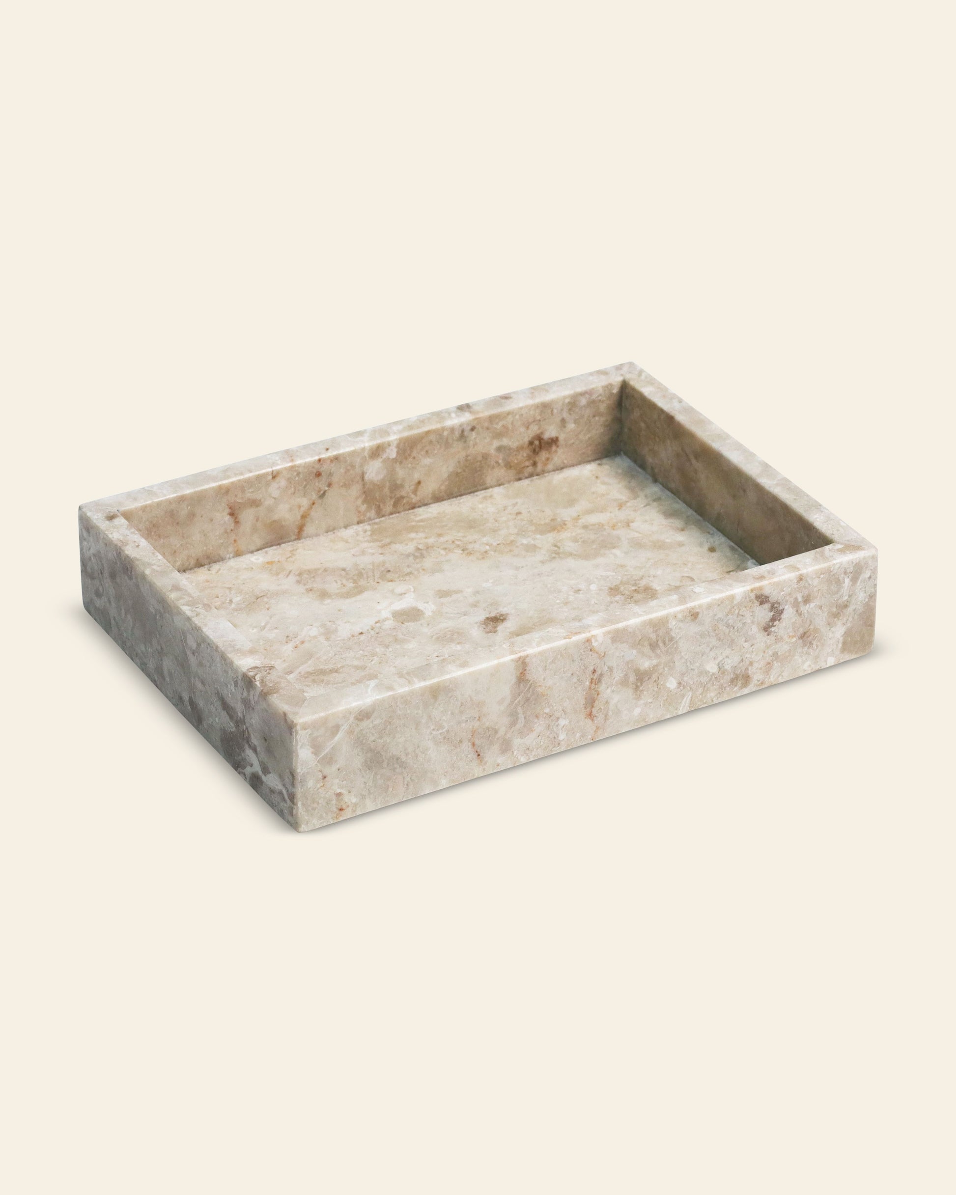 The stillgoods Mini Valor Tray features a low-profile rectangular design with raised edges and a polished light brown and beige marble pattern—ideal for keeping your essentials organized and stylish on any off-white surface.