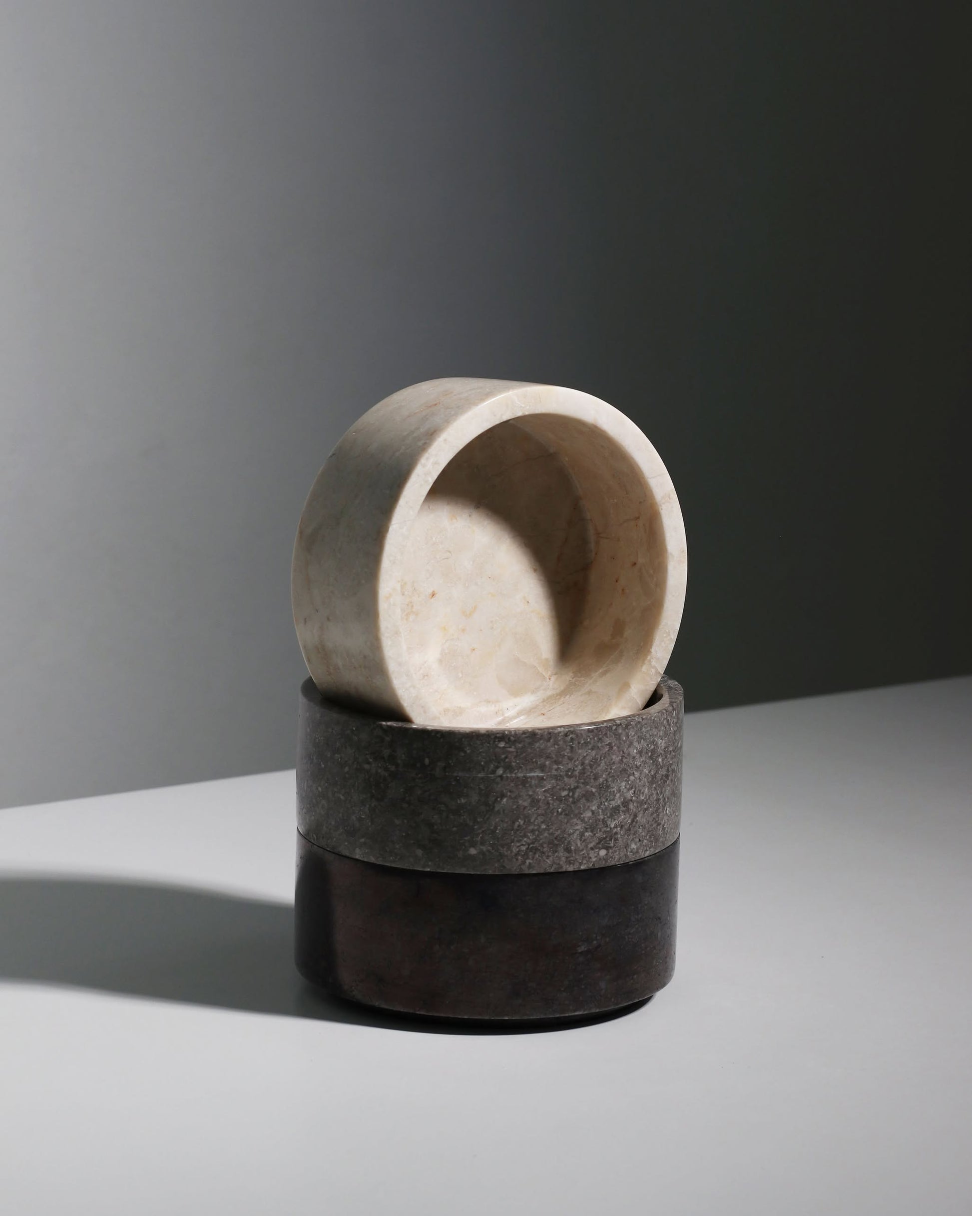 A stack of three stillgoods Tingkat Bowls in marble and onyx, featuring cream, gray, and dark brown shades, displayed on a white surface with a soft shadow for a minimalist look.