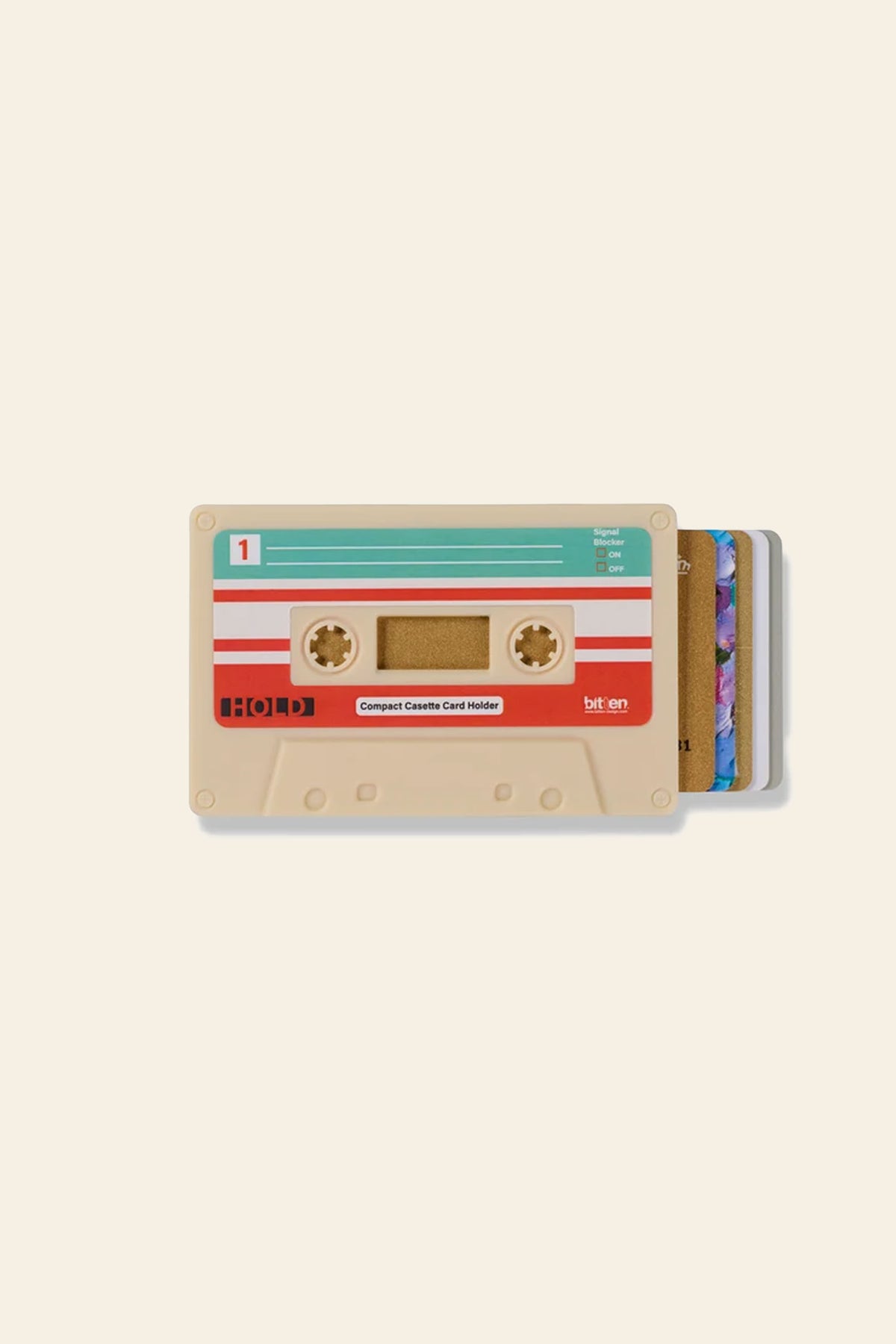The Bitten Cassette Card Holder by Bitten features RFID protection and retro design, with cards partially visible on the right side, shown on a plain beige background.