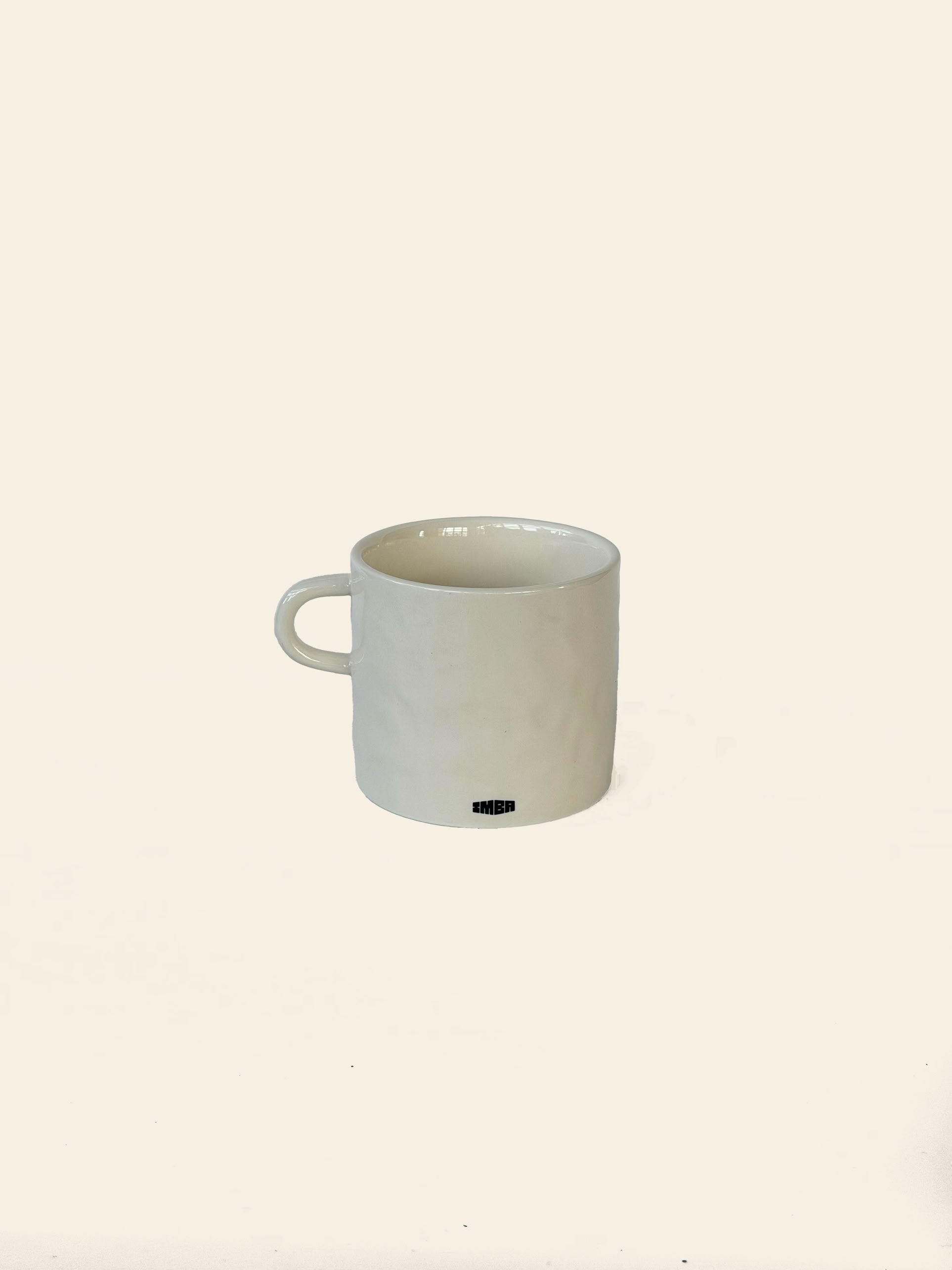 A white ceramic David Hockney Love Life Mug with a handle rests on a plain light background. A small black logo or text, characteristic of the David Hockney brand, appears near the base on the front side, lending an artistic touch to this classic ceramic piece.