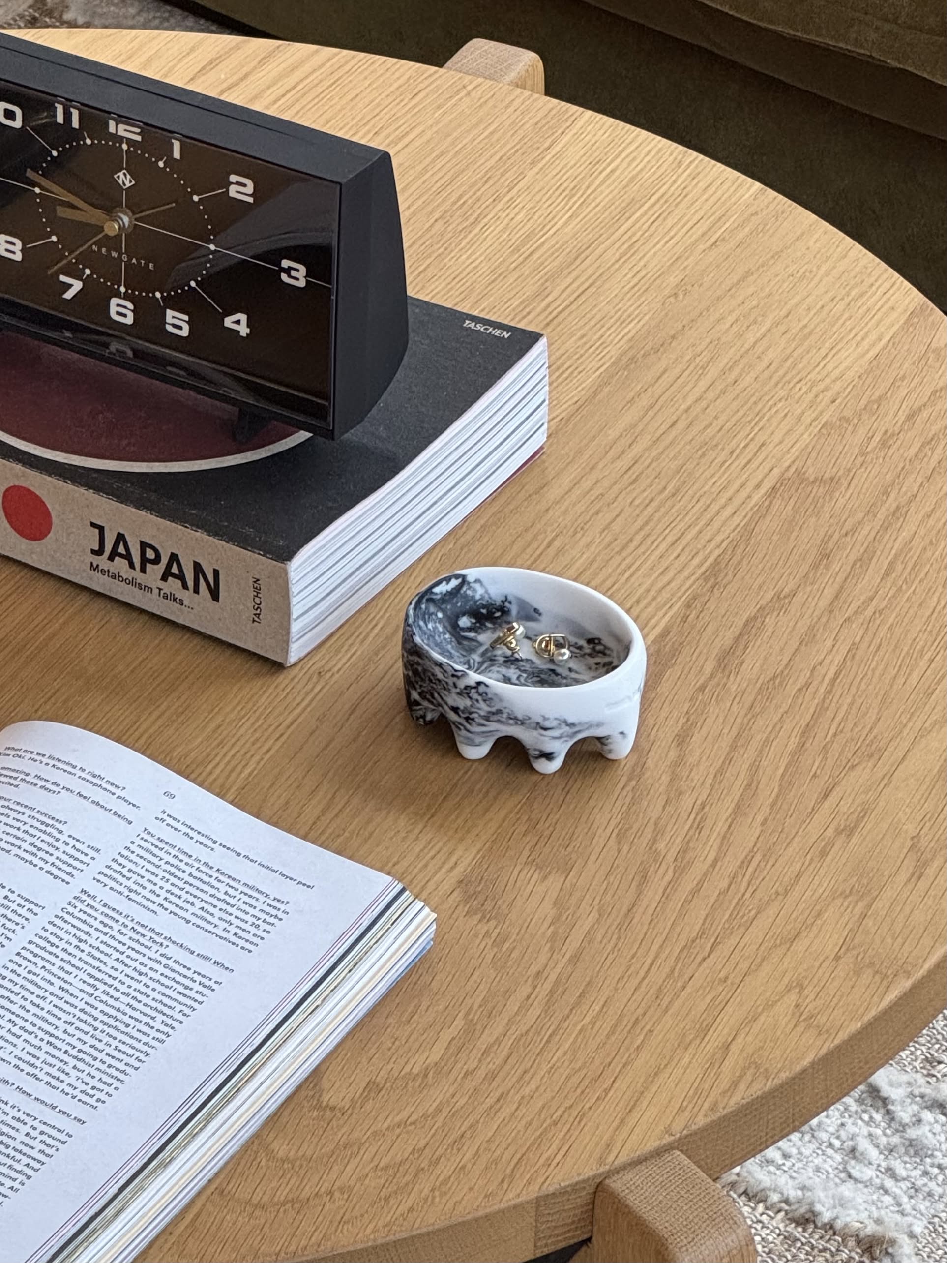 A small, round ice cube with melting drips sits alone against a plain off-white background, evoking the sculptural touch and minimalist elegance of the Dinosaur Designs Crown Dish by Dinosaur Designs.
