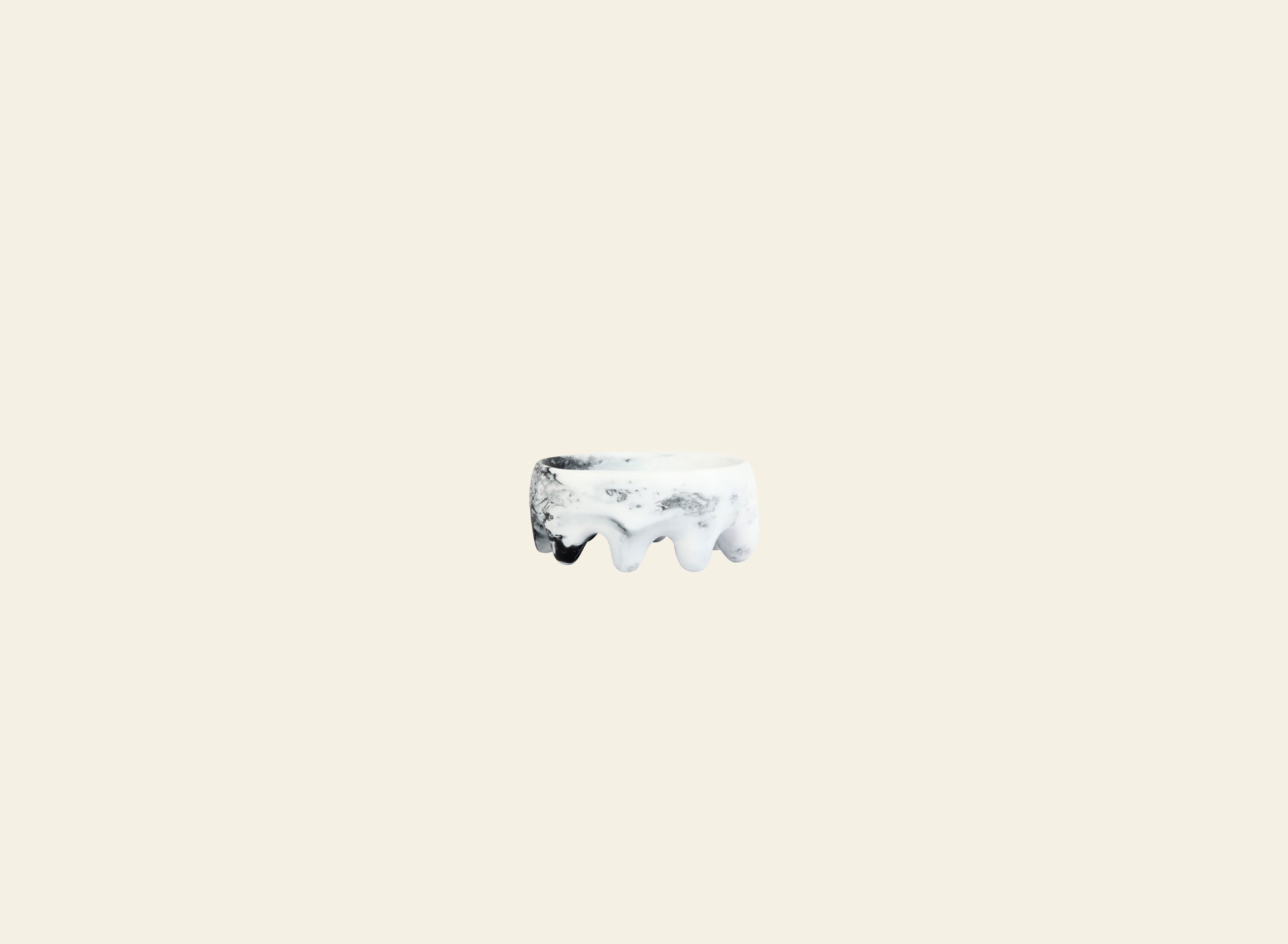 A small, round Dinosaur Designs Crown Dish sits centered on a plain light beige background, its sculptural white form echoing the iconic style of Dinosaur Designs.