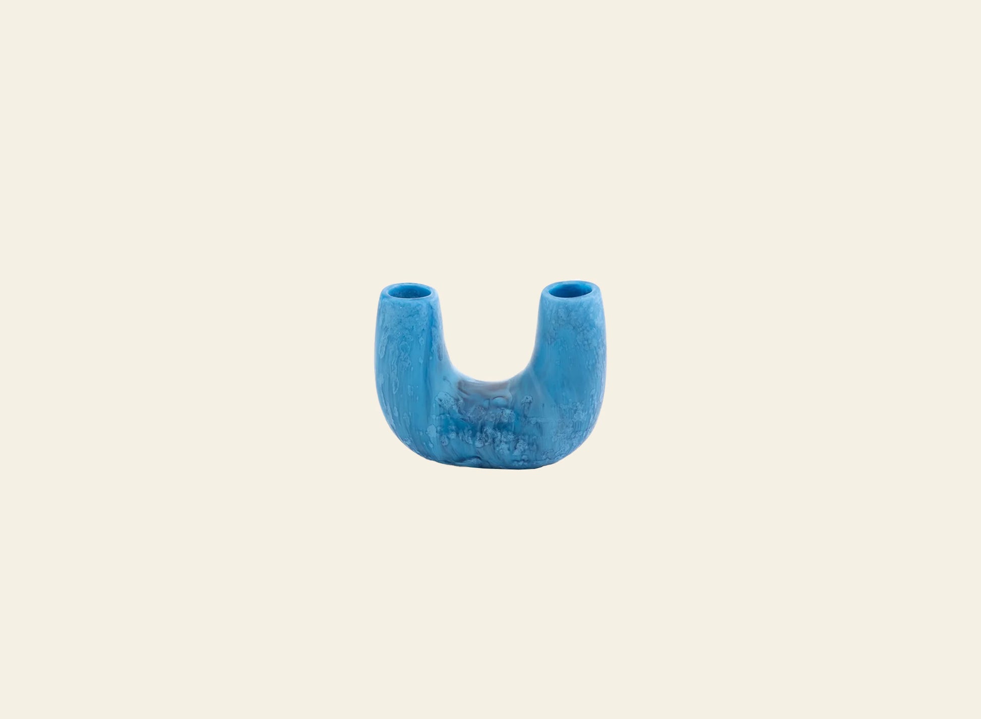 The Dinosaur Designs Mini Branch Vase, a blue U-shaped ceramic piece with two openings, stands upright against a plain light beige background.