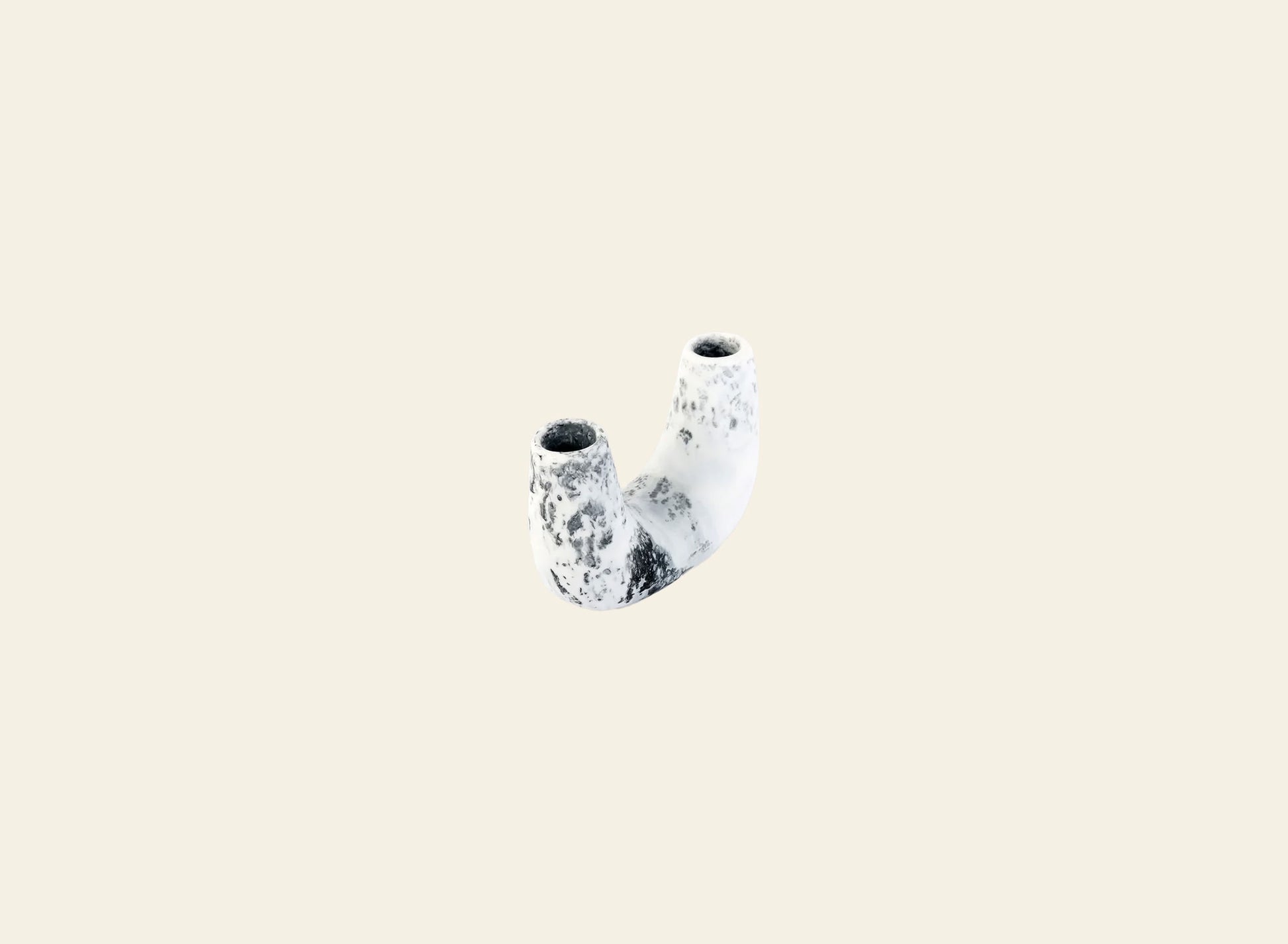 The Dinosaur Designs Mini Branch Vase, a small curved ceramic piece with two cylindrical openings and a white-and-black speckled pattern, is shown against a plain beige background.