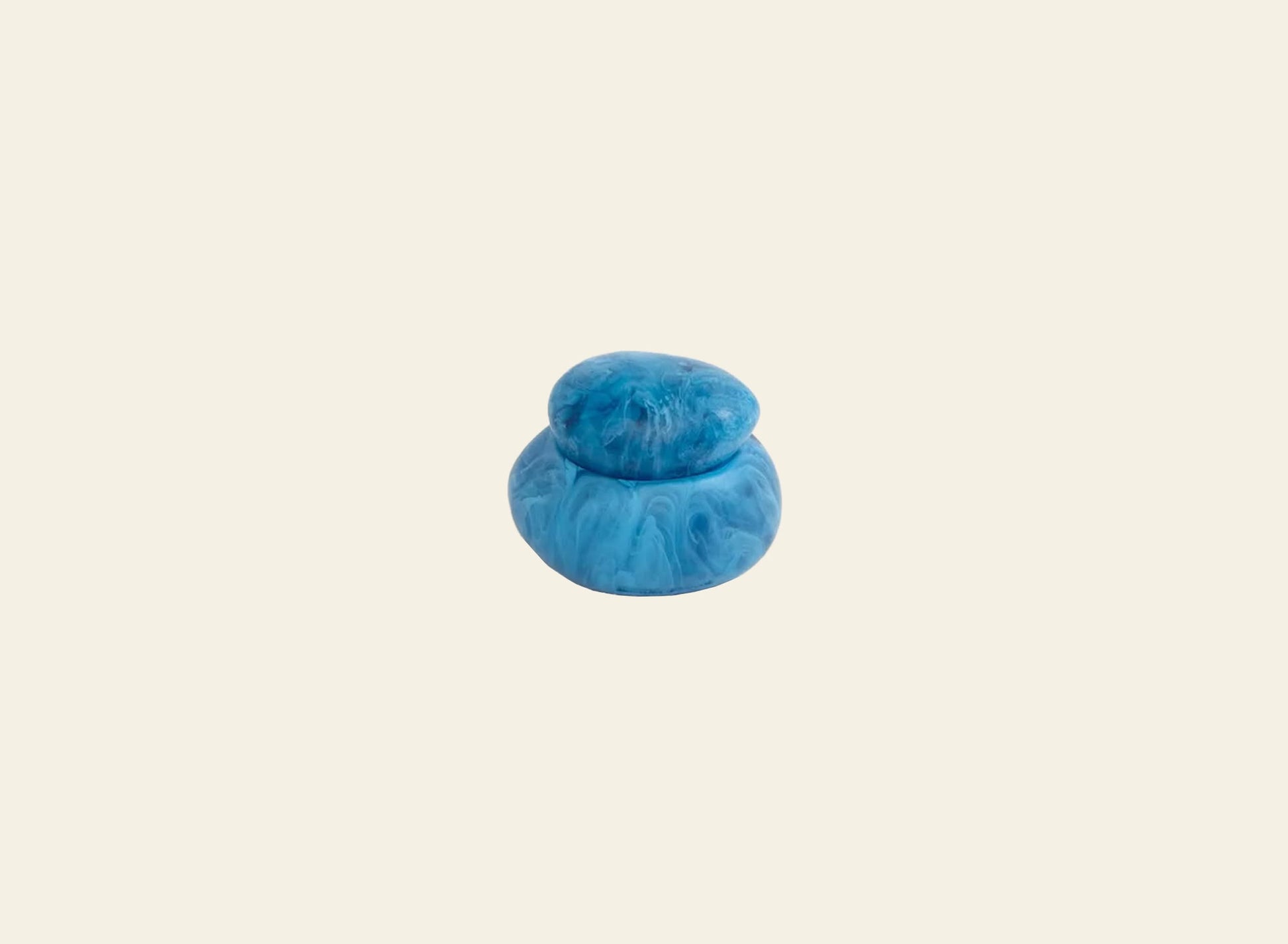 The Dinosaur Designs Small Pebble Jar by Dinosaur Designs is a blue, marbled, sculptural jar with a matching lid, shown against a plain light beige background.
