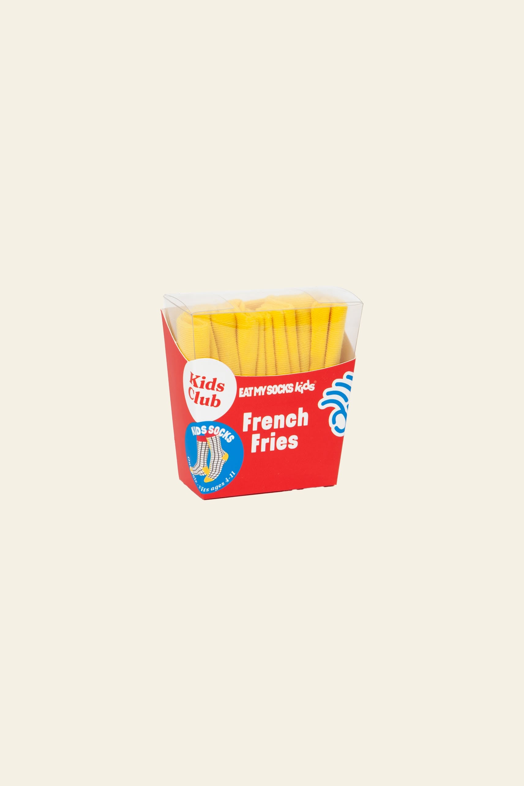 A hand holds an Eat My Socks French Fries Kids Socks box by Eat My Socks on a round wooden table, surrounded by colorful, food-themed toy boxes—fun as a gift for kids or for storing playful French fries socks.