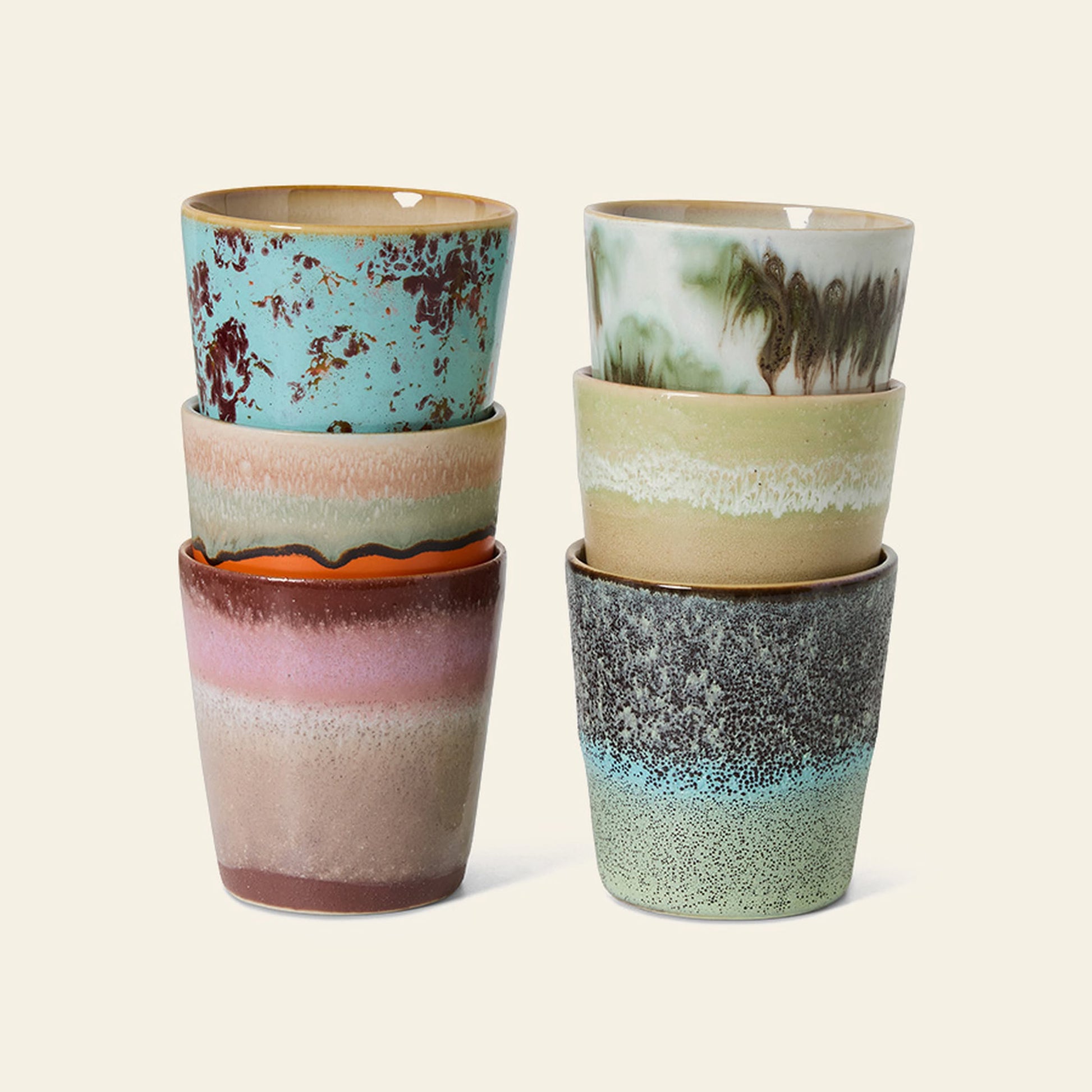 The HKliving 70s Ceramics: Coffee Mugs, Set of 6 features uniquely patterned stoneware mugs in earthy tones, blue, green, and pink glazes on neutral backgrounds, inspired by retro designs.