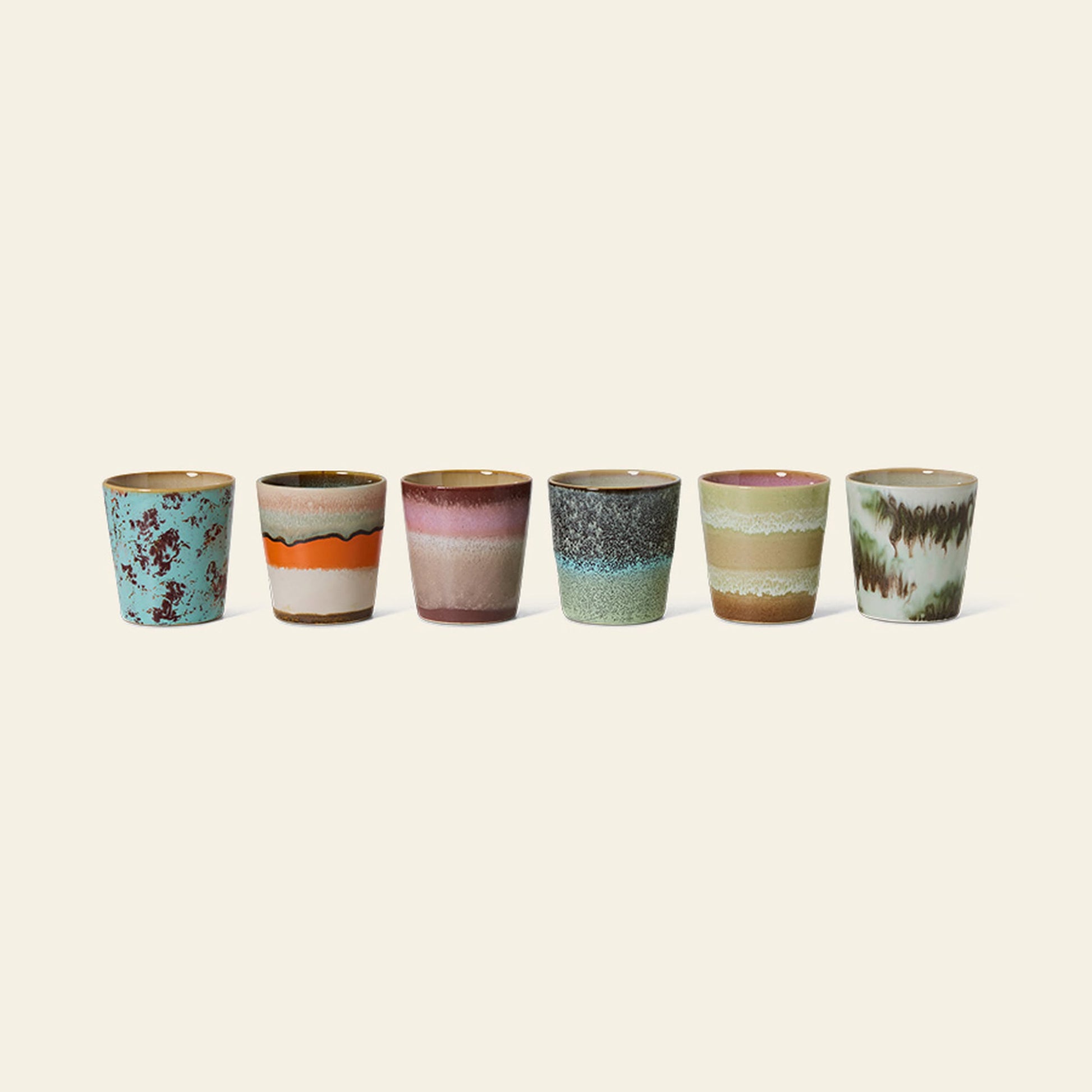 The HKliving 70s Ceramics Coffee Mugs, Set of 6, showcases unique, colorful glazed patterns in retro styles, arranged against a light beige background. Each mug features distinct shades and textures for a nostalgic touch.