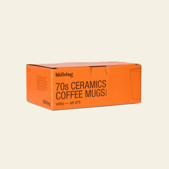 An orange rectangular box labeled HKliving 70s Ceramics: Coffee Mugs, Set of 6 is displayed against a plain background, with minimal line mug drawings decorating its sides.