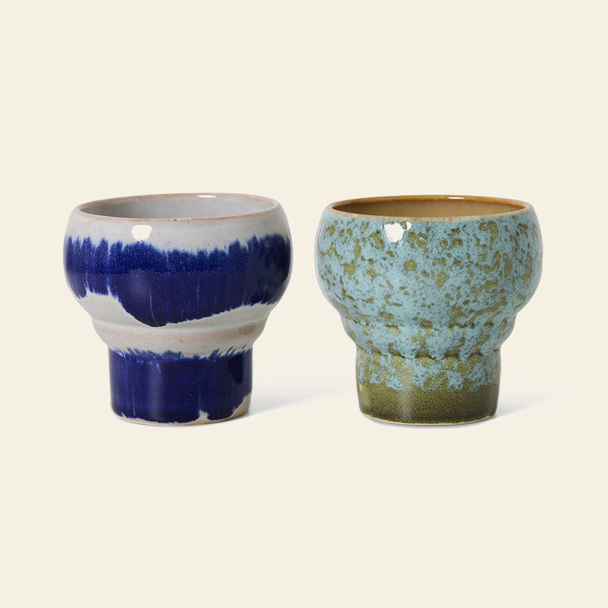 The HKliving 70s Ceramics: Lungo Mugs, Set of 2, features two handcrafted mugs with unique blue-toned designs and a retro rounded shape—perfect for coffee lovers. From the HKliving brand.