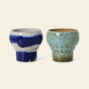 The HKliving 70s Ceramics: Lungo Mugs, Set of 2, features two handcrafted mugs with unique blue-toned designs and a retro rounded shape—perfect for coffee lovers. From the HKliving brand.