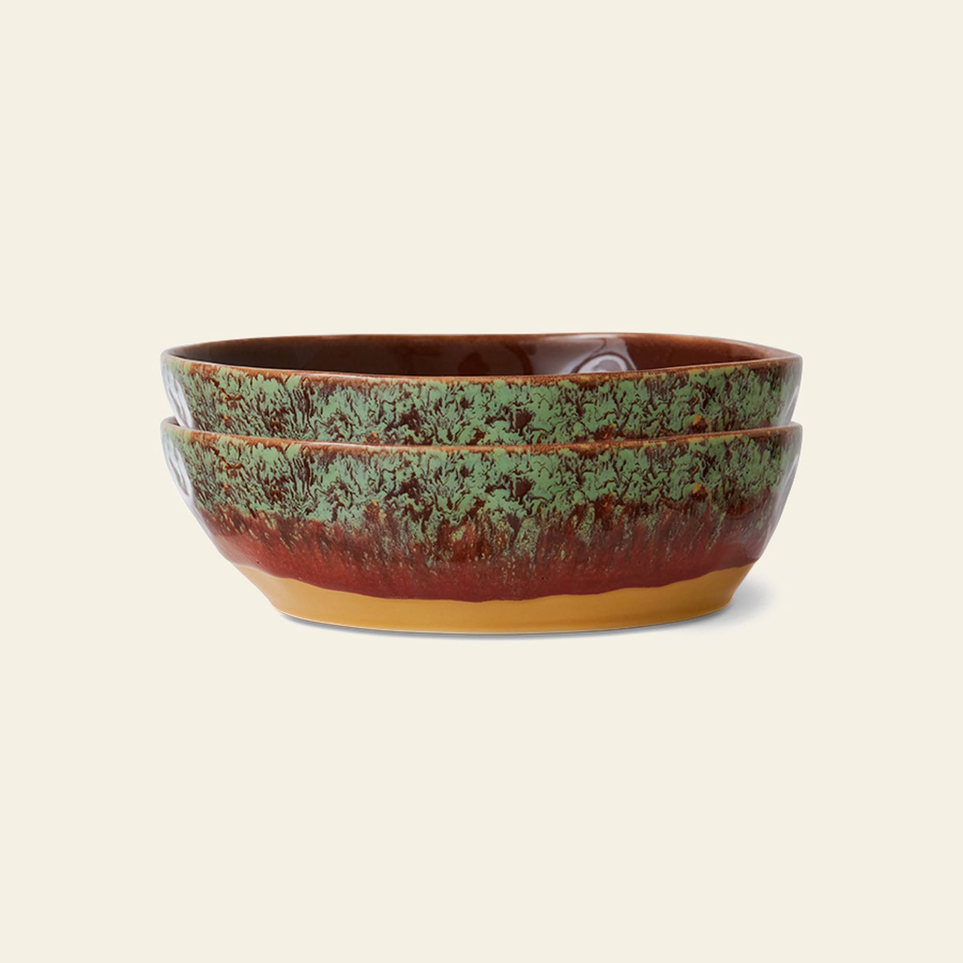 The HKliving 70s Ceramics: Pasta Bowls, Set of 2, feature a textured green and brown glaze with a yellowish base, stacked together to evoke vintage charm against a light background.
