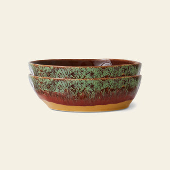 The HKliving 70s Ceramics: Pasta Bowls, Set of 2, feature a textured green and brown glaze with a yellowish base, stacked together to evoke vintage charm against a light background.