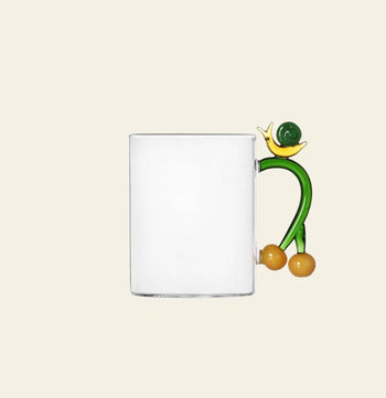 The Ichendorf Milano Fruits and Flower Mug features a playful abstract handle with yellow and green accents—an eye-catching clear glass design by Ichendorf Milano, perfect for any fruit and flower mug collection.