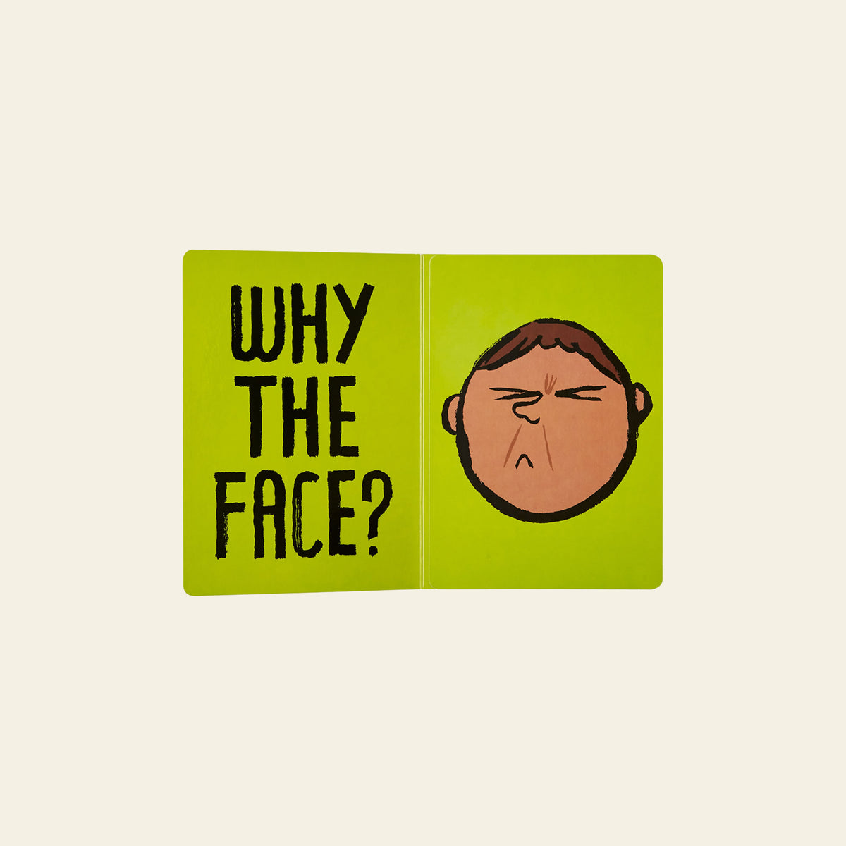 A green board book spread from Phaidon Why The Face? by Phaidon displays the text “WHY THE FACE?” on the left page and a cartoon face with a frowning, displeased expression on the right, helping little ones explore emotional awareness through facial expressions.