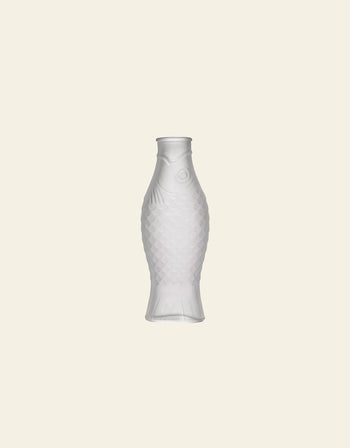 A frosted white Serax Fish & Fish Carafe by Serax, shaped like a fish, sits centered on a plain light beige background, making a stylish statement in unique tableware.