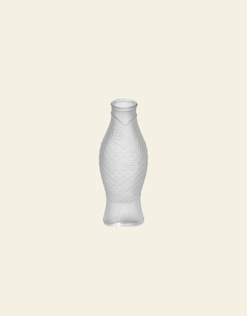 The Serax Fish & Fish Carafe by Serax, with its translucent, textured fish design, stands upright on a light beige background—an eye-catching piece to bring unique charm to your tableware setting.