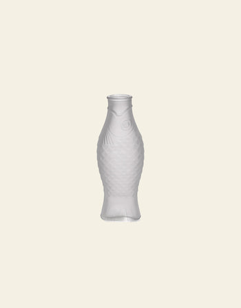 The Serax Fish & Fish Carafe by Serax, shaped like a fish, stands upright against a light beige background—an eye-catching piece ideal as unique tableware or a charming carafe for your table setting.