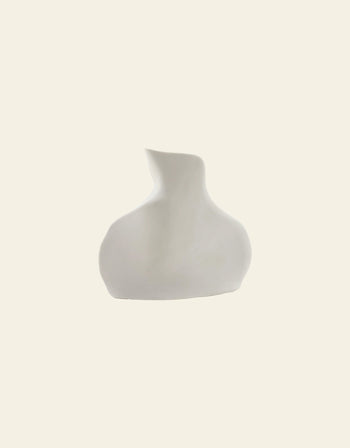 The Serax Perfect Imperfection Flower Vase N°5 in white features a minimalist abstract design with a wide base and an irregular narrow neck, set against a plain off-white background.