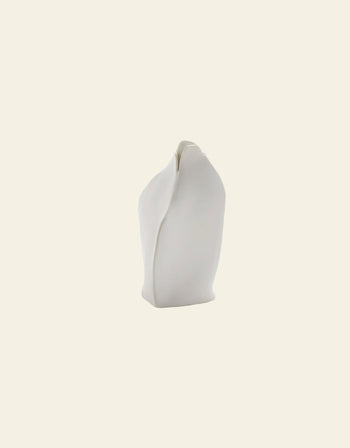 The Serax Perfect Imperfection Flower Vase S N°1 in white features smooth, rounded edges and an organically twisted form, inspired by Roos van de Velde. Styled simply against a plain light beige background.