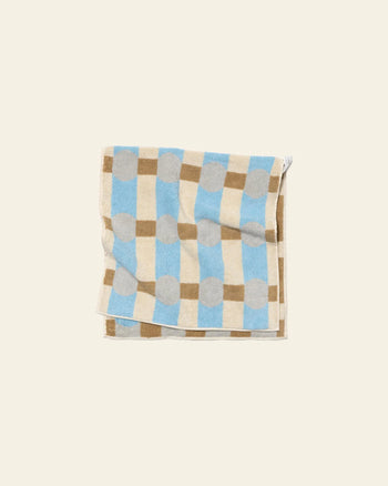 The WARMGREY TAIL Dot Check Face Towel by WARMGREY TAIL is a quality cotton terry towel featuring blue, beige, brown, and gray checkered and polka dot patterns on an off-white background.